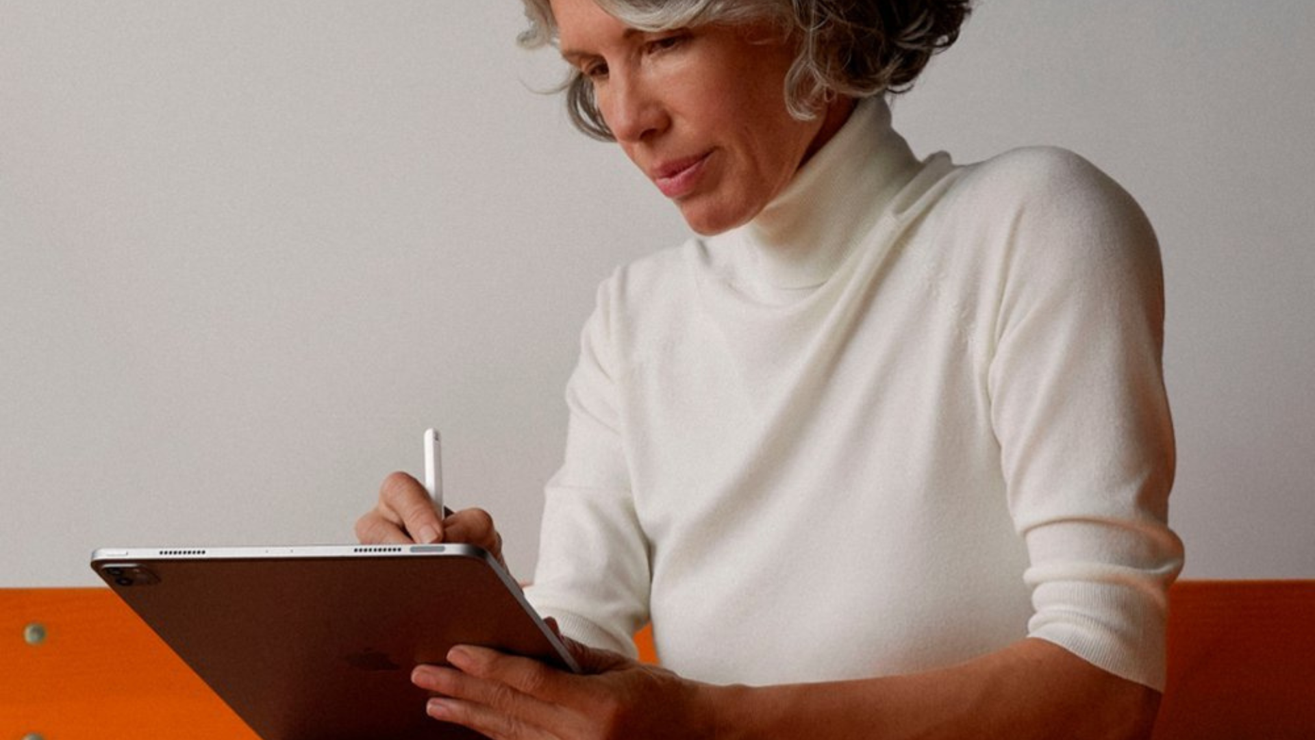 A person using an iPad with an Apple Pencil