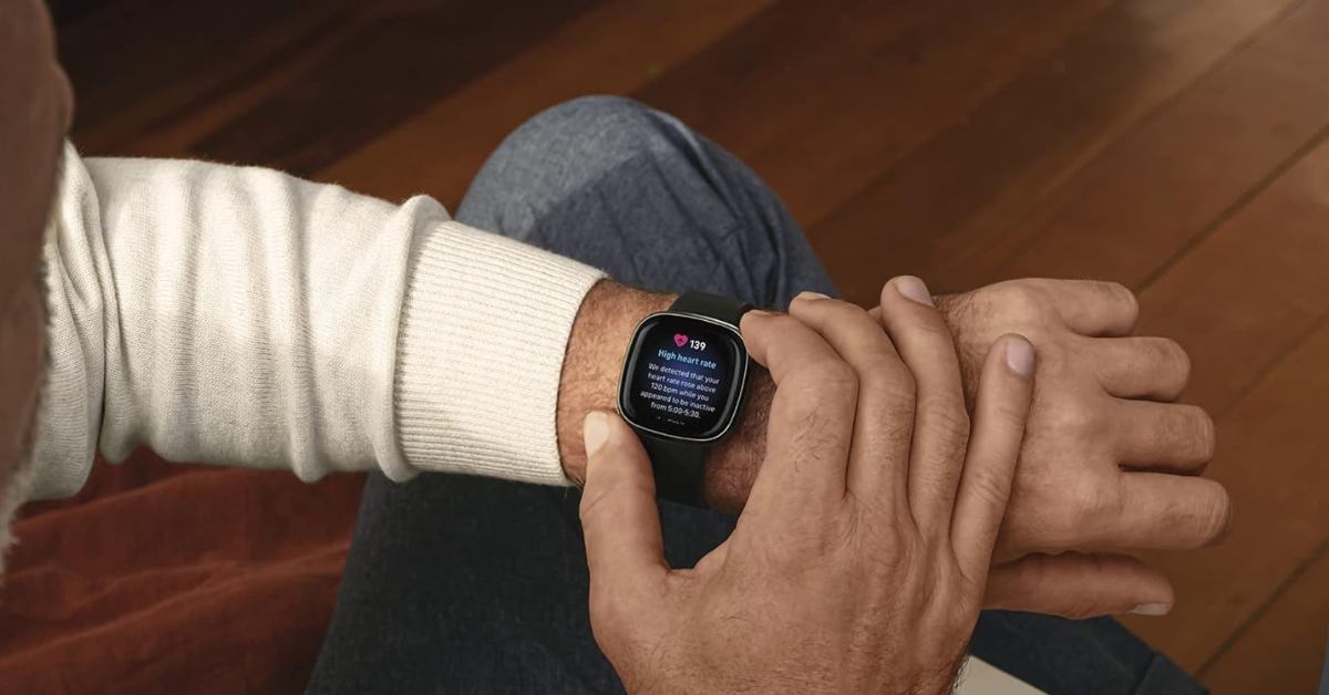 Man looking at a Fitbit Sense smartwatch 