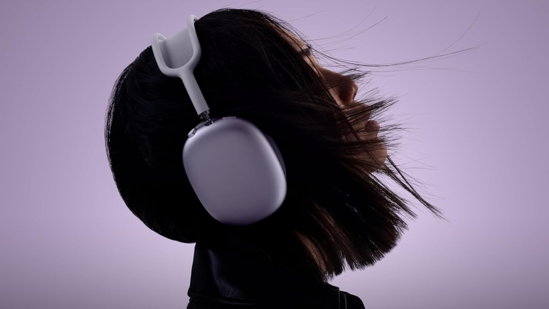 A person wearing a pair of purple AirPods Max.