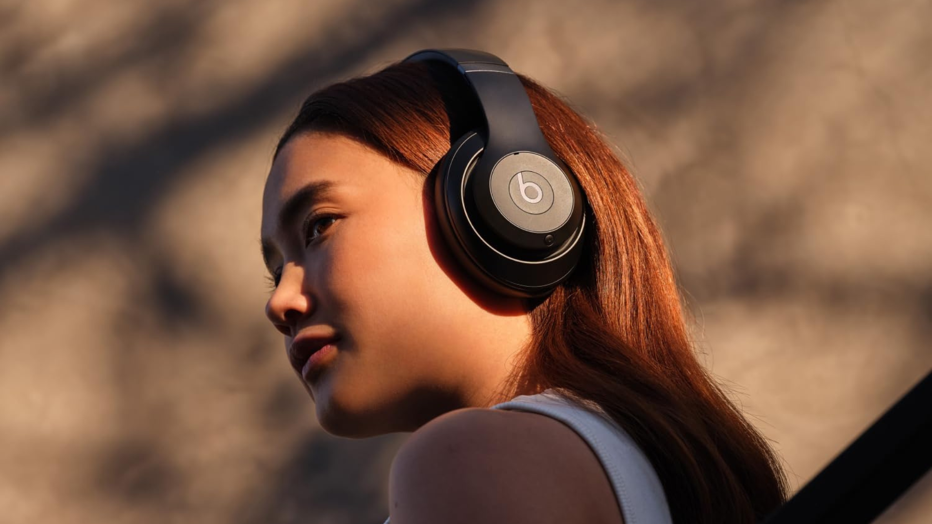 A person wearing a pair of Beats Studio Pro headphones