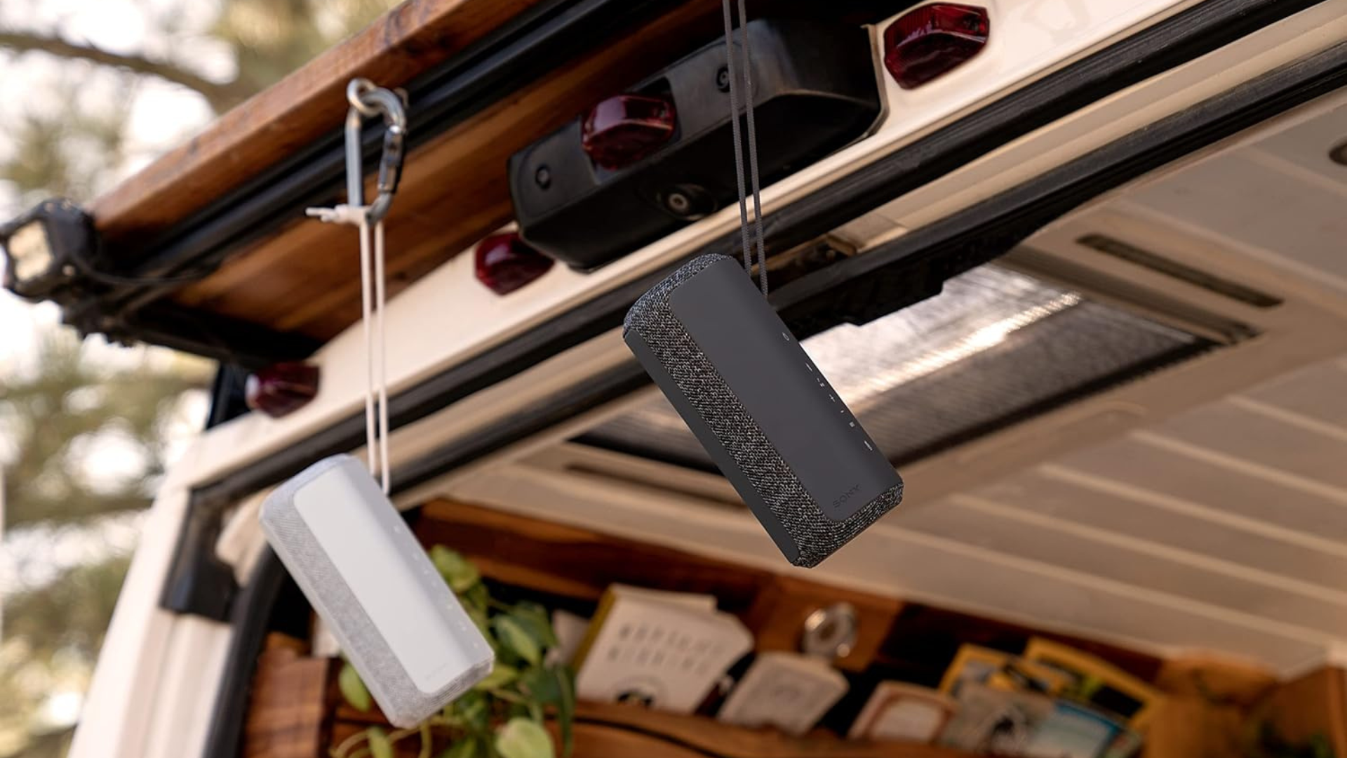 A set of Sony speakers hanging from a car trunk.