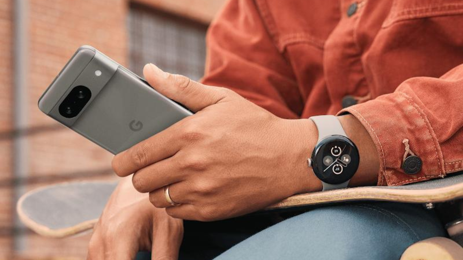 close up of person using Google Pixel 8 phone and wearing Google Pixel Watch