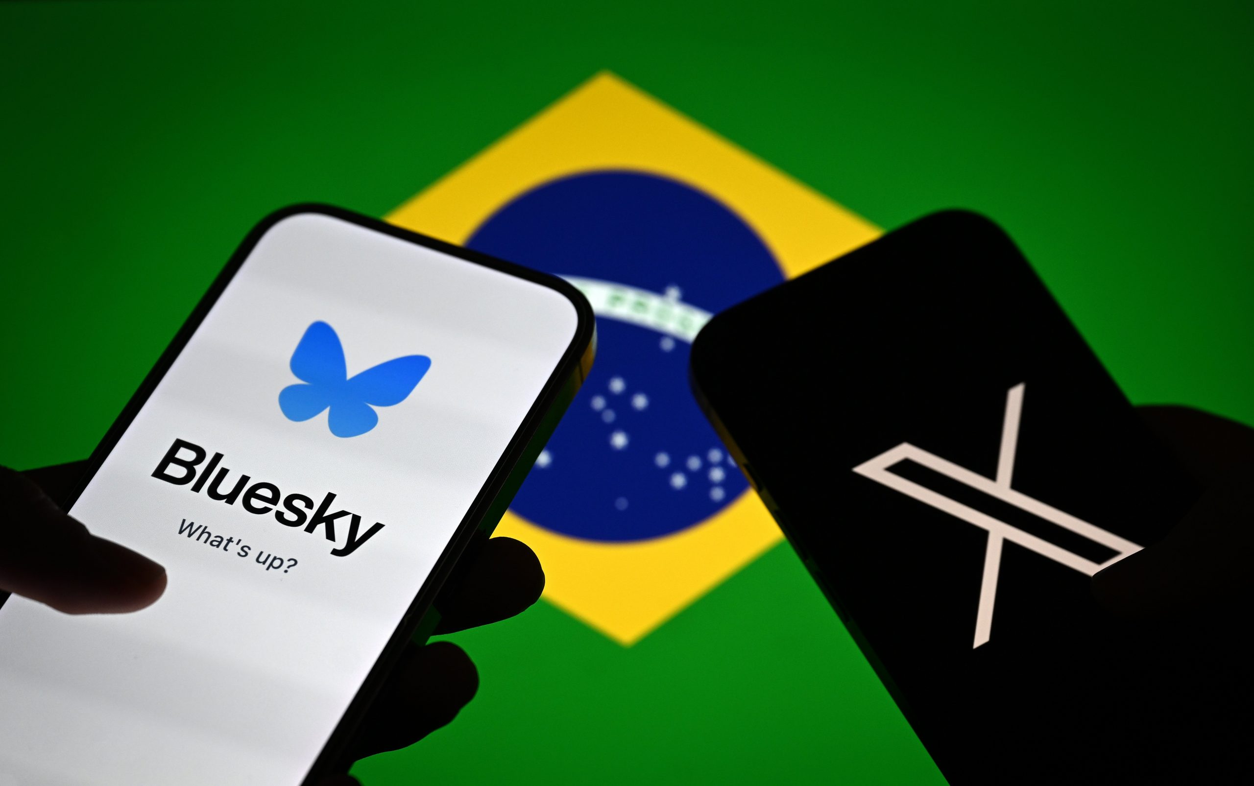 X and Bluesky on smartphones with Brazil's flag in the background