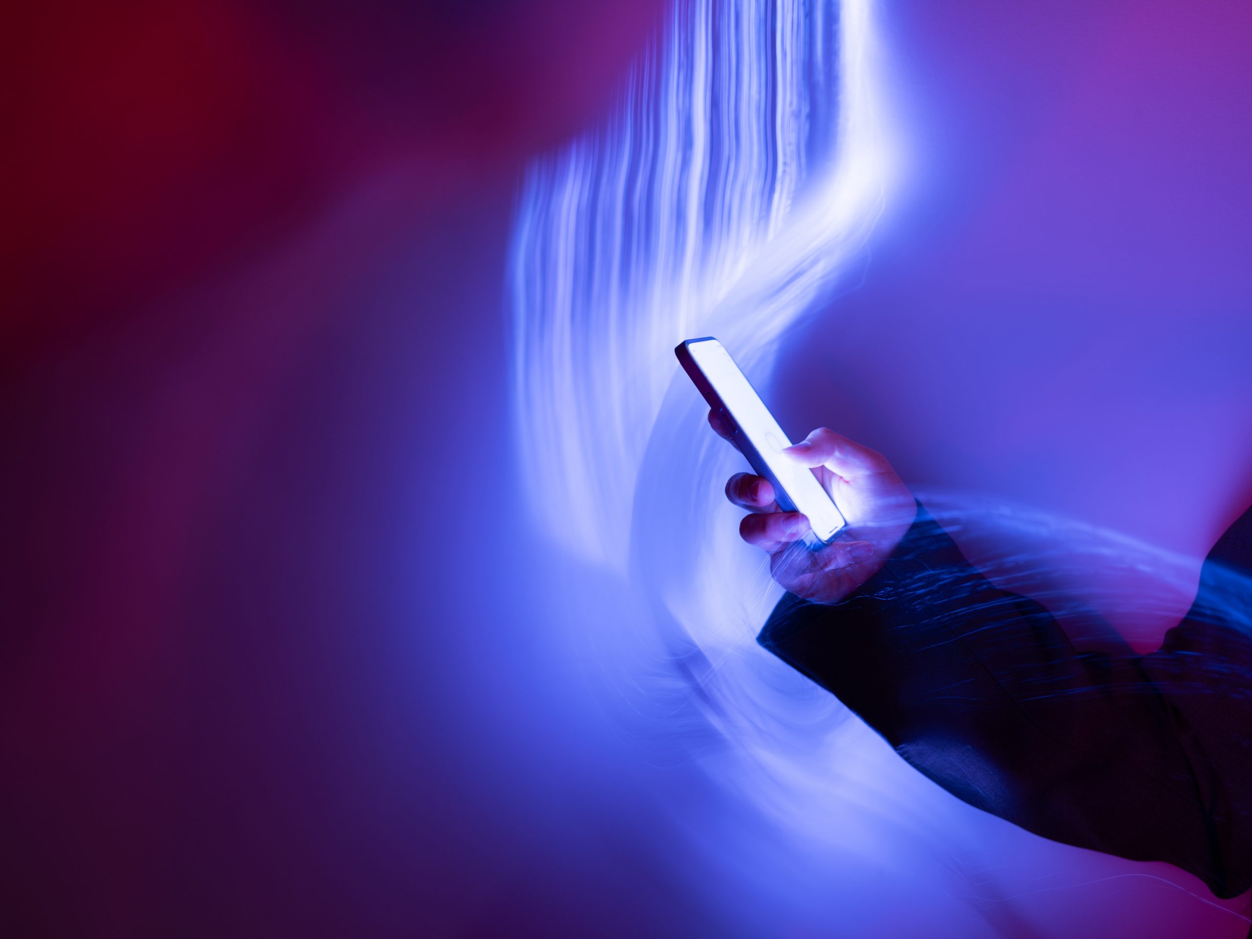 Close-up of using mobile phone on holographic background