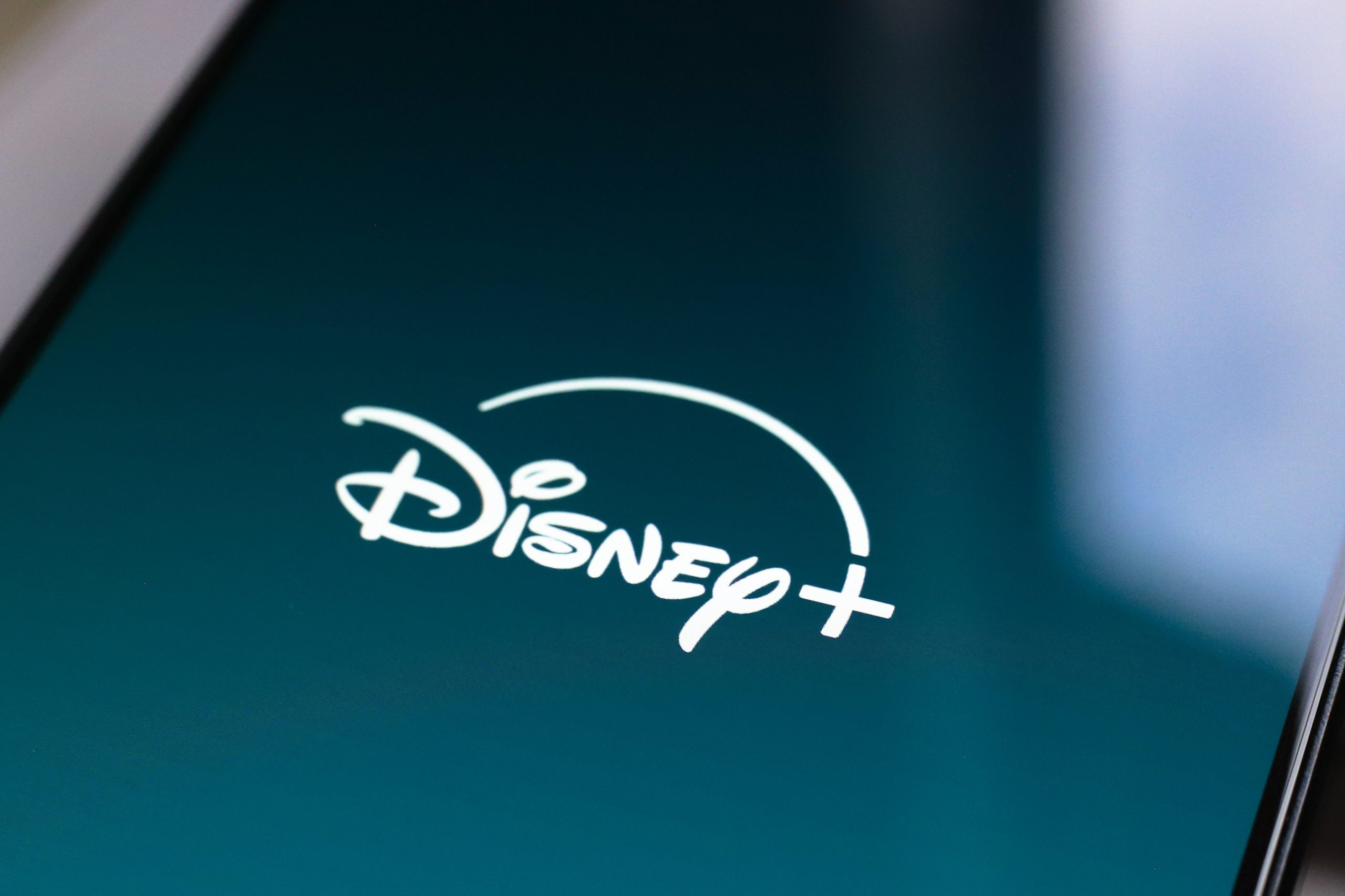 In this photo illustration, the Disney Plus streaming app logo is displayed on the smartphone screen