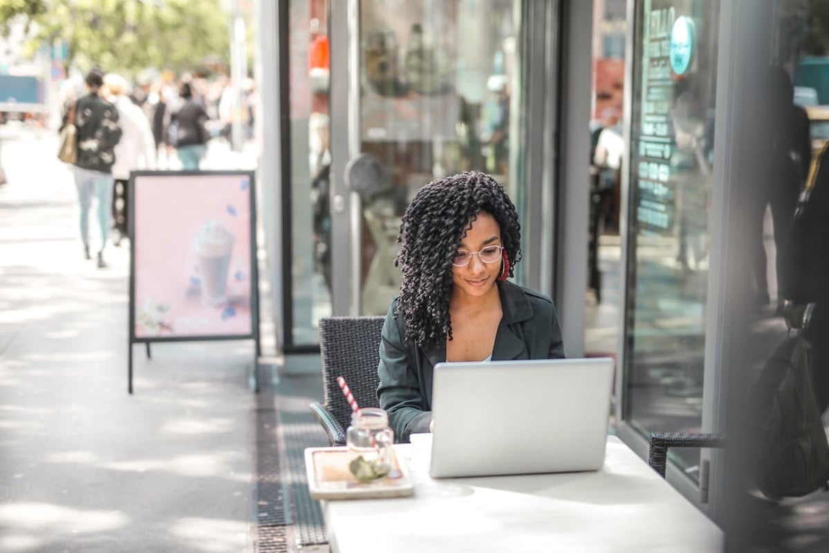 young woman on laptop while sitting outside