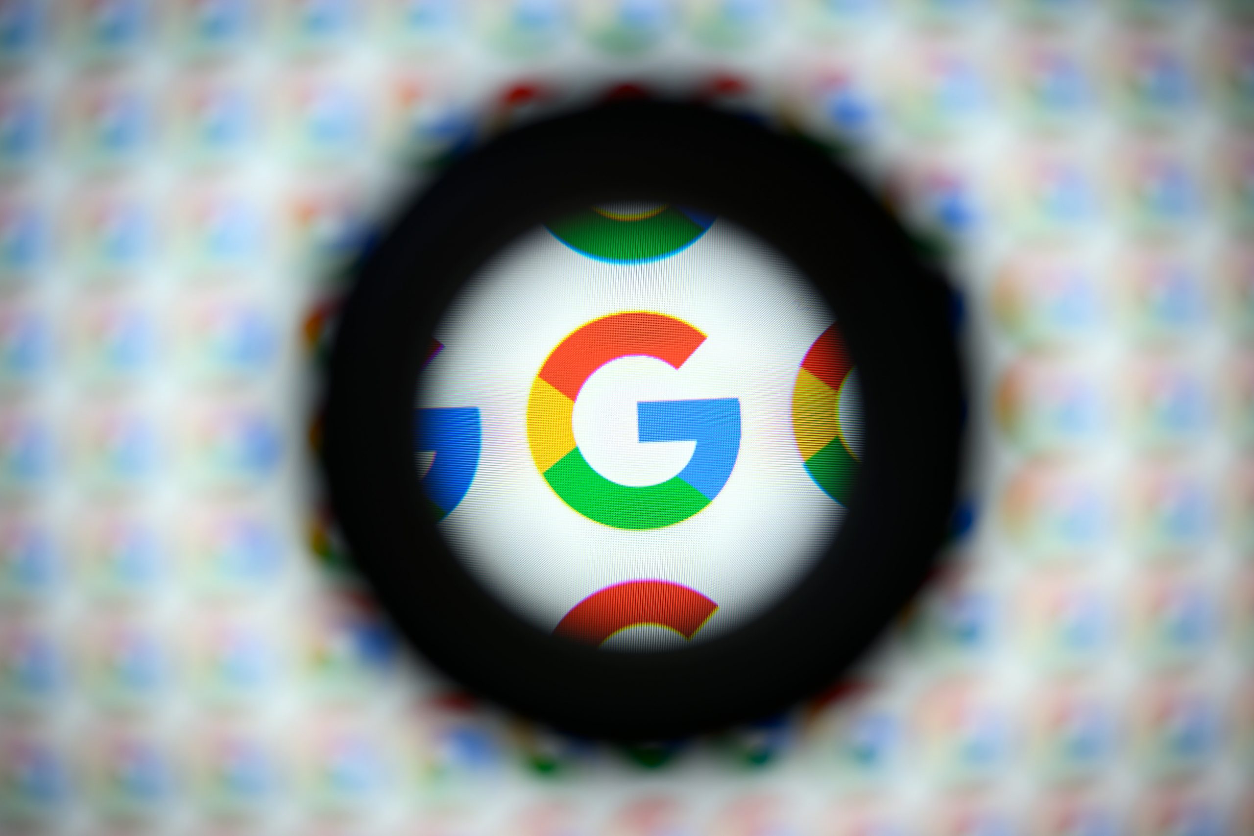 A magnified Google logo on a blurry background.