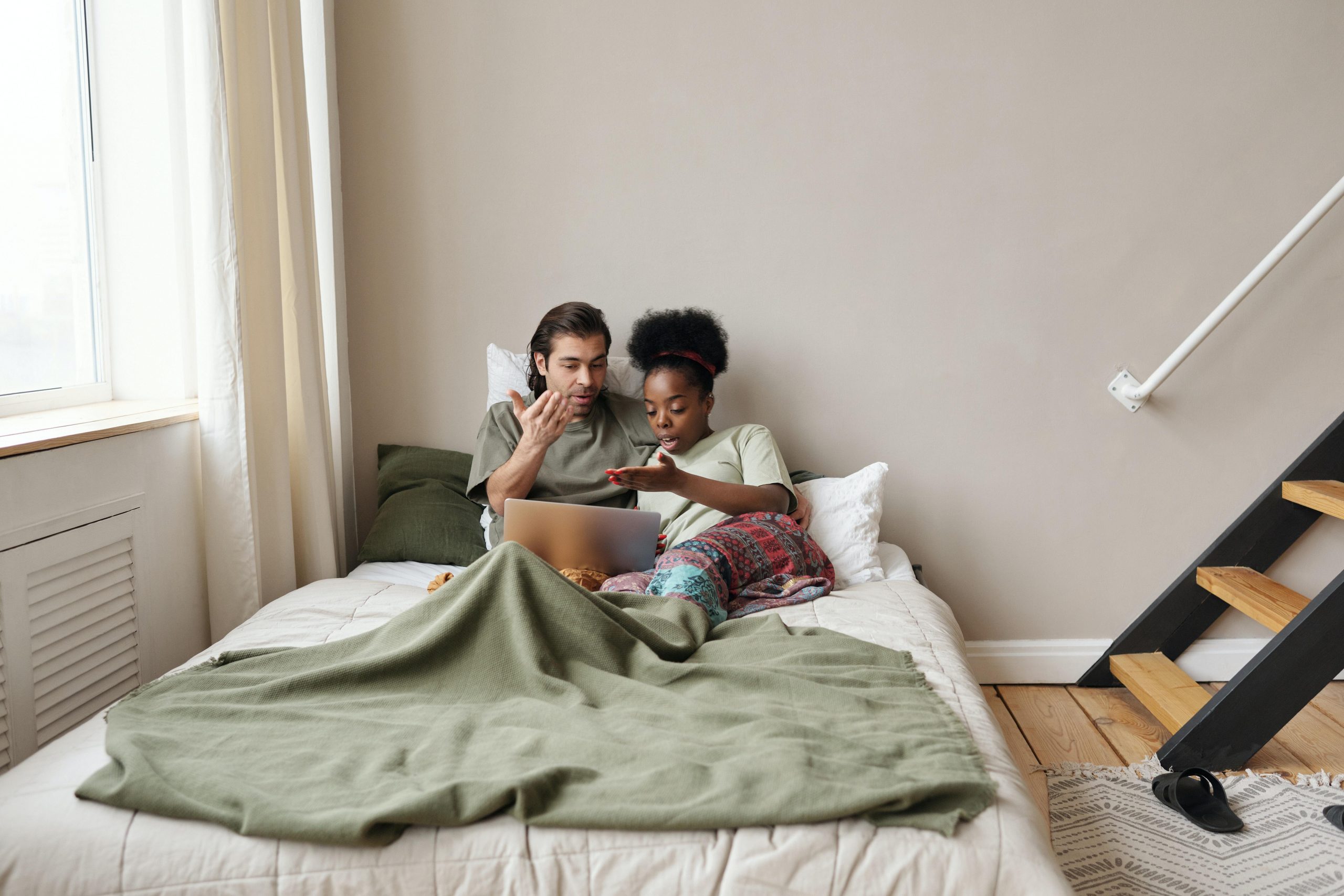 Couple watching laptop on bed