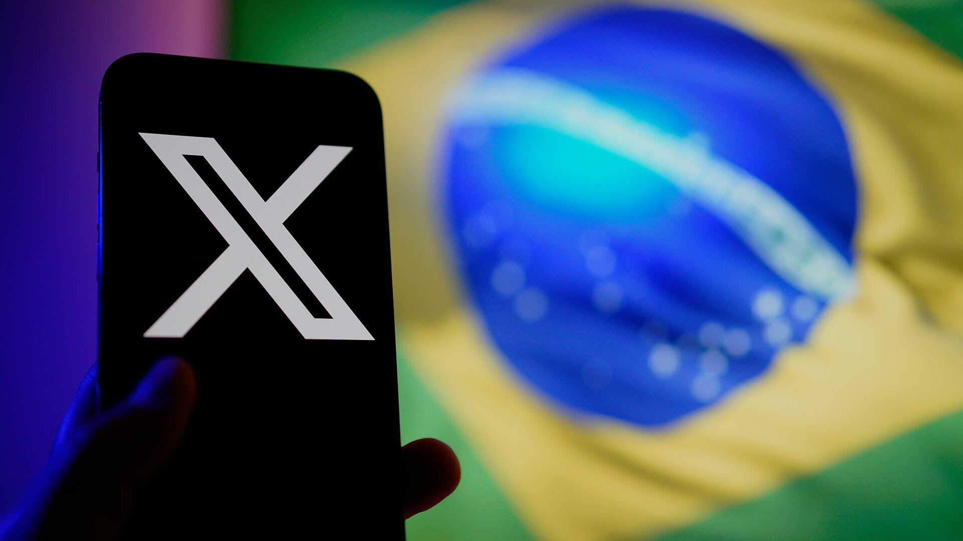 A smartphone shows the X logo. In the background the Brazilian flag is visible.