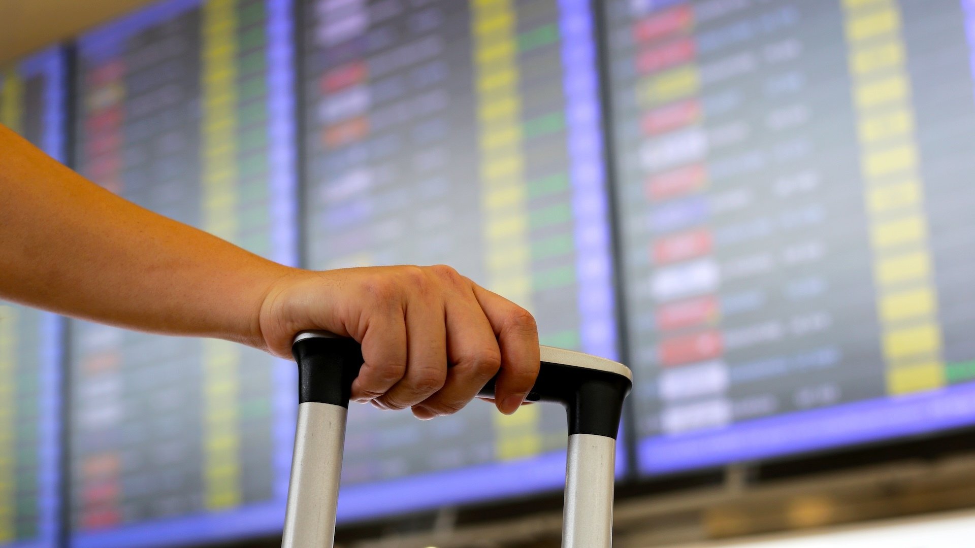 A person wheels luggage through an airport.