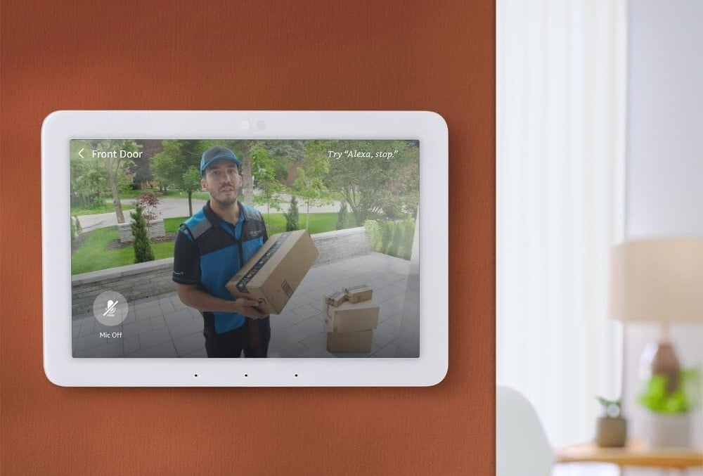 the amazon echo hub on a wall in a home displays the image from a video doorbell