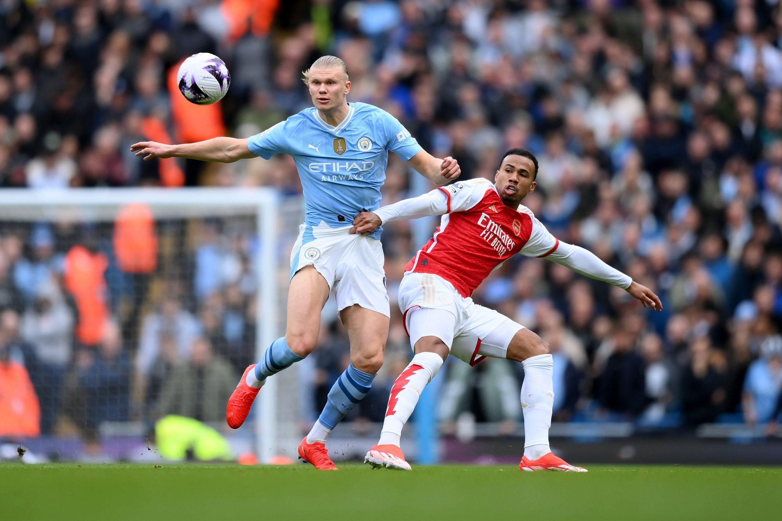 Erling Haaland of Manchester City is challenged by Gabriel of Arsenal