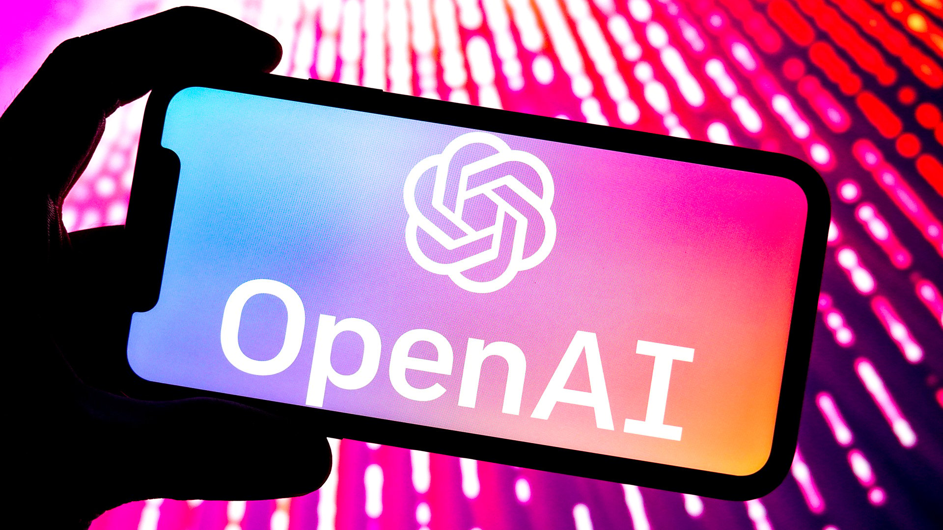 A person holding a smartphone that shows the OpenAI logo on the screen.