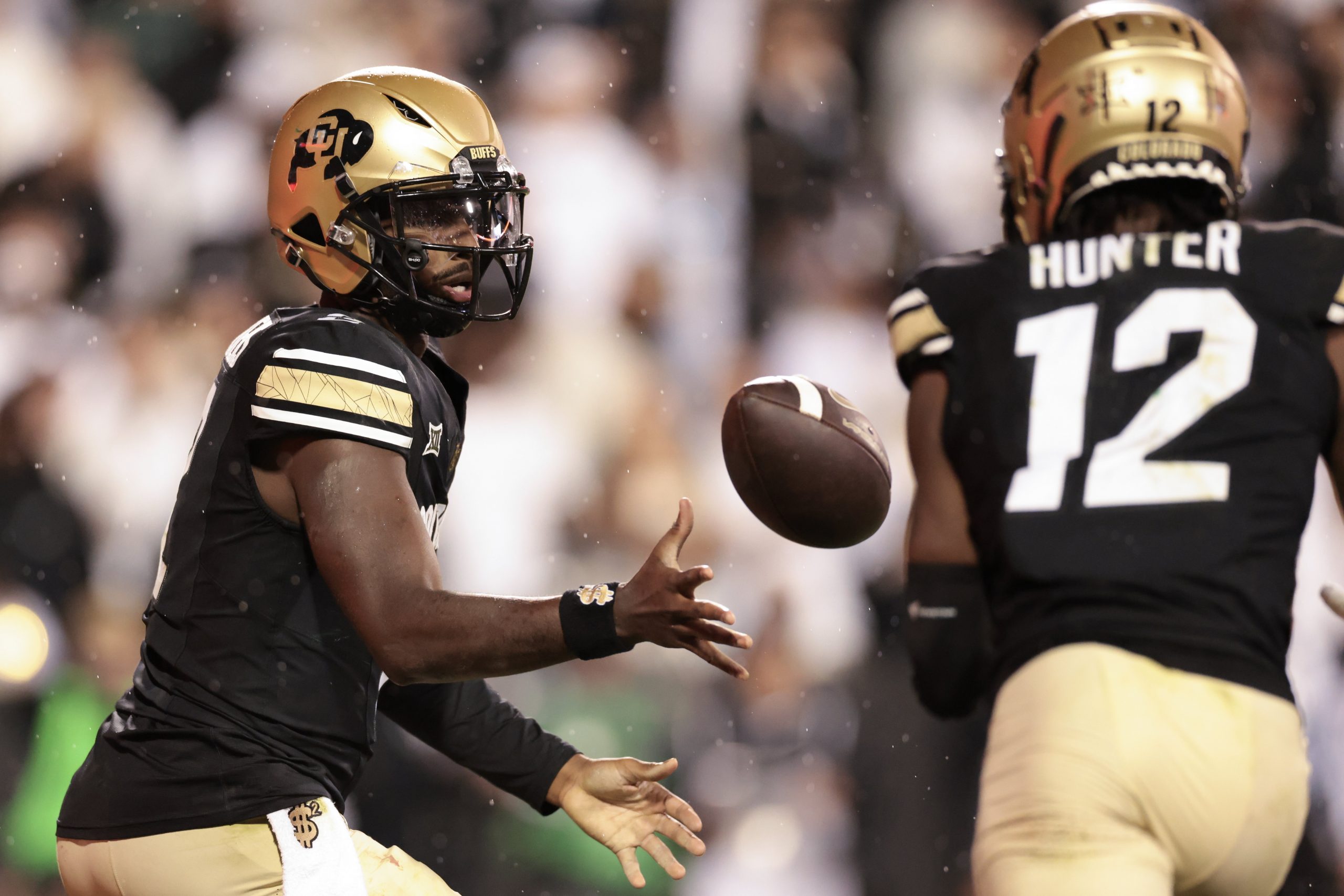 Shedeur Sanders #2 tosses the ball to Travis Hunter #12 of the Colorado Buffaloes during the second half against the Baylor Bears at Folsom Field on Sept. 21, 2024, in Boulder, Colorado.