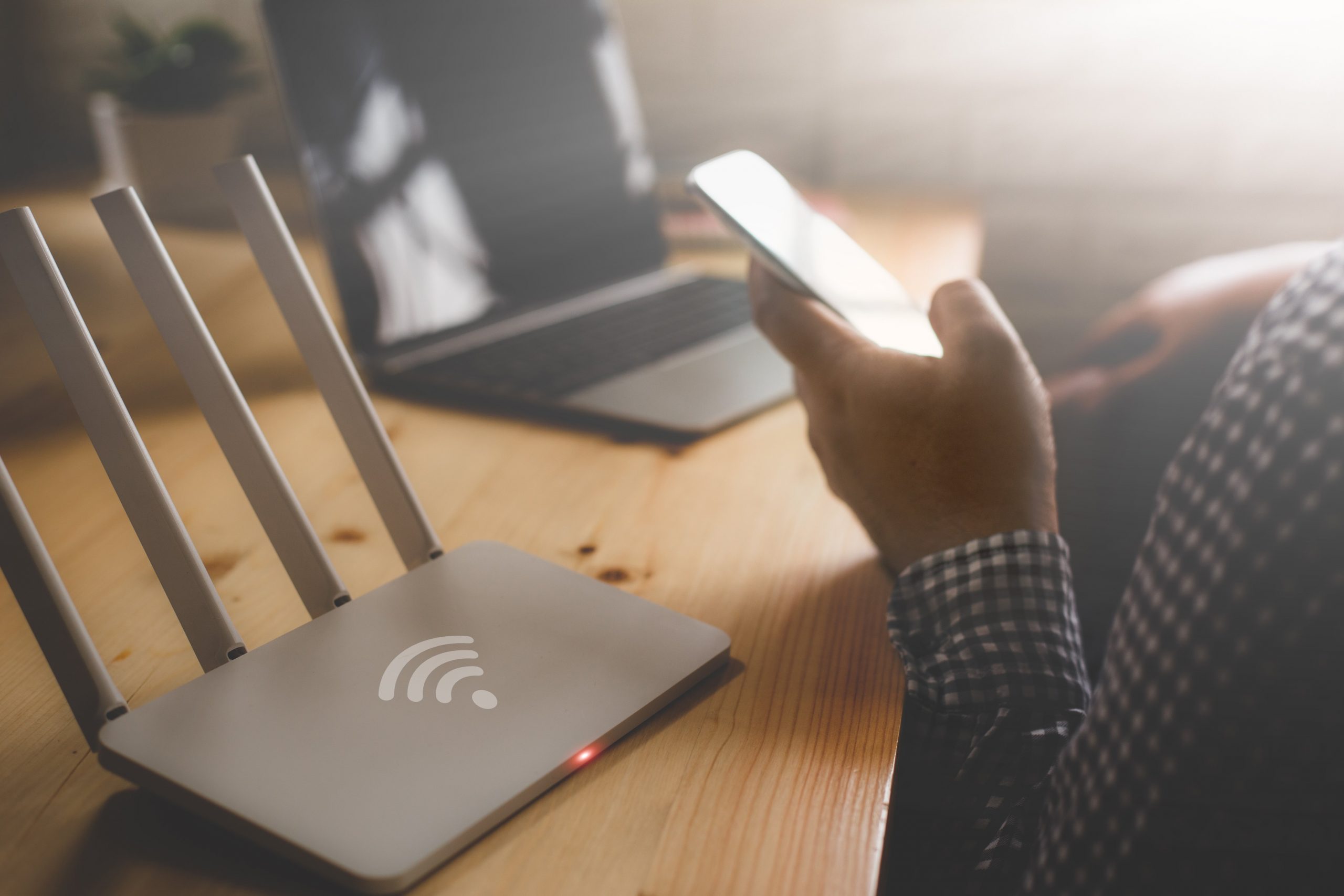 a Wi-Fi router and a person holding a mobile phone