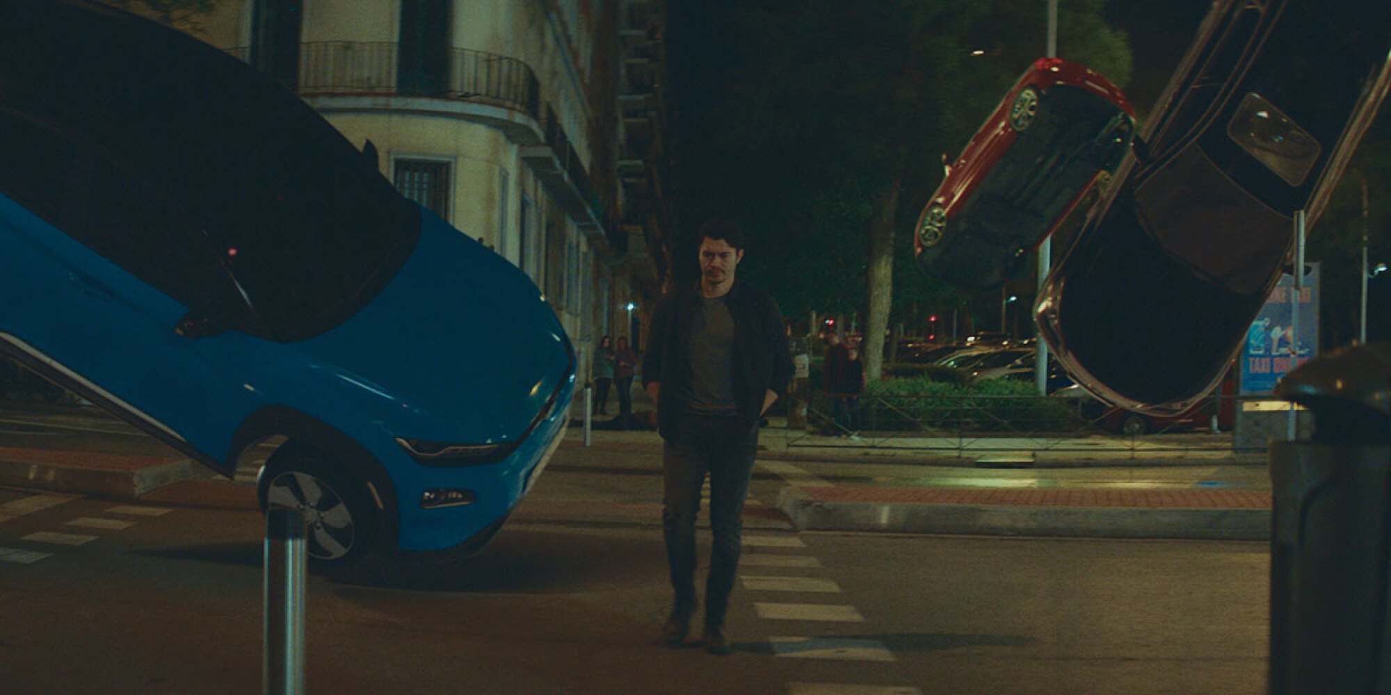 Henry Golding walks through traffic in "Daniela Forever."