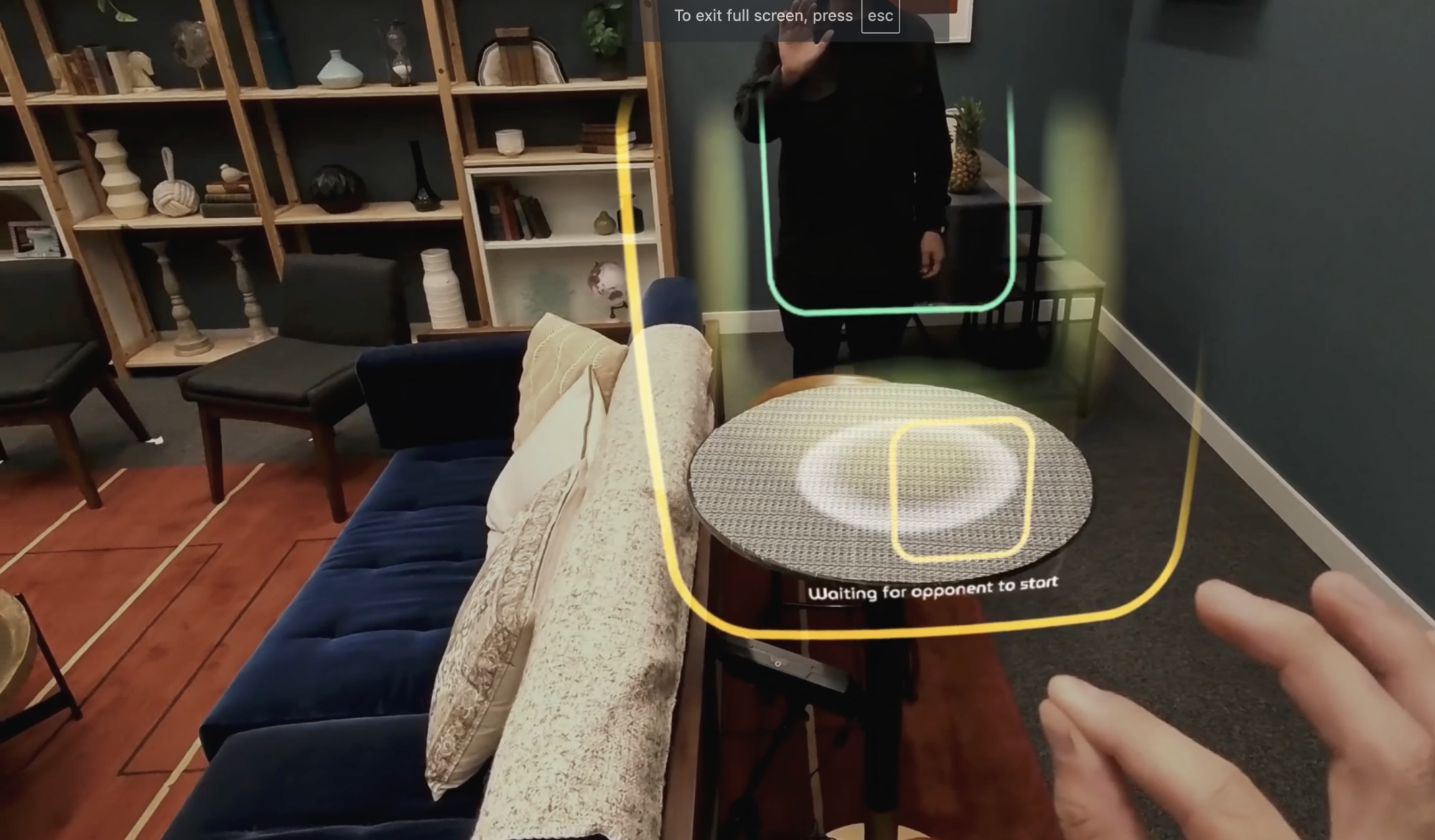 Person interacting with a mixed-reality interface in a modern living room, with virtual game elements overlaying the physical environment, waiting for an opponent to join