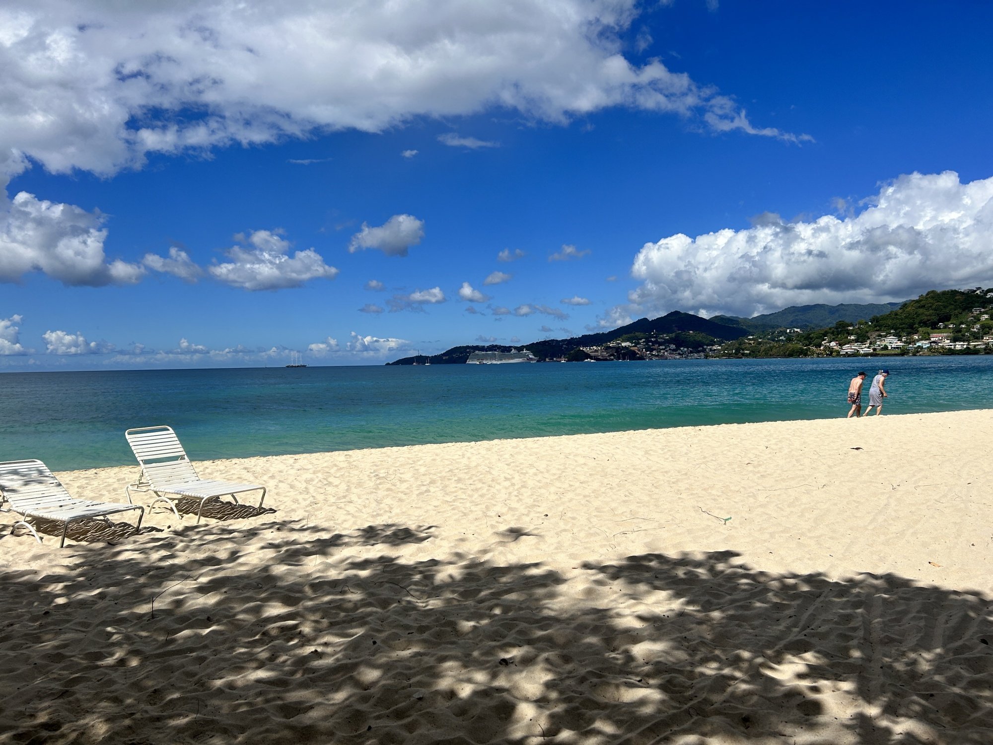 A stunning beach in Grenada with a couple walking in the distance