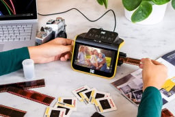 person feeding film into KODAK REELS digitizer