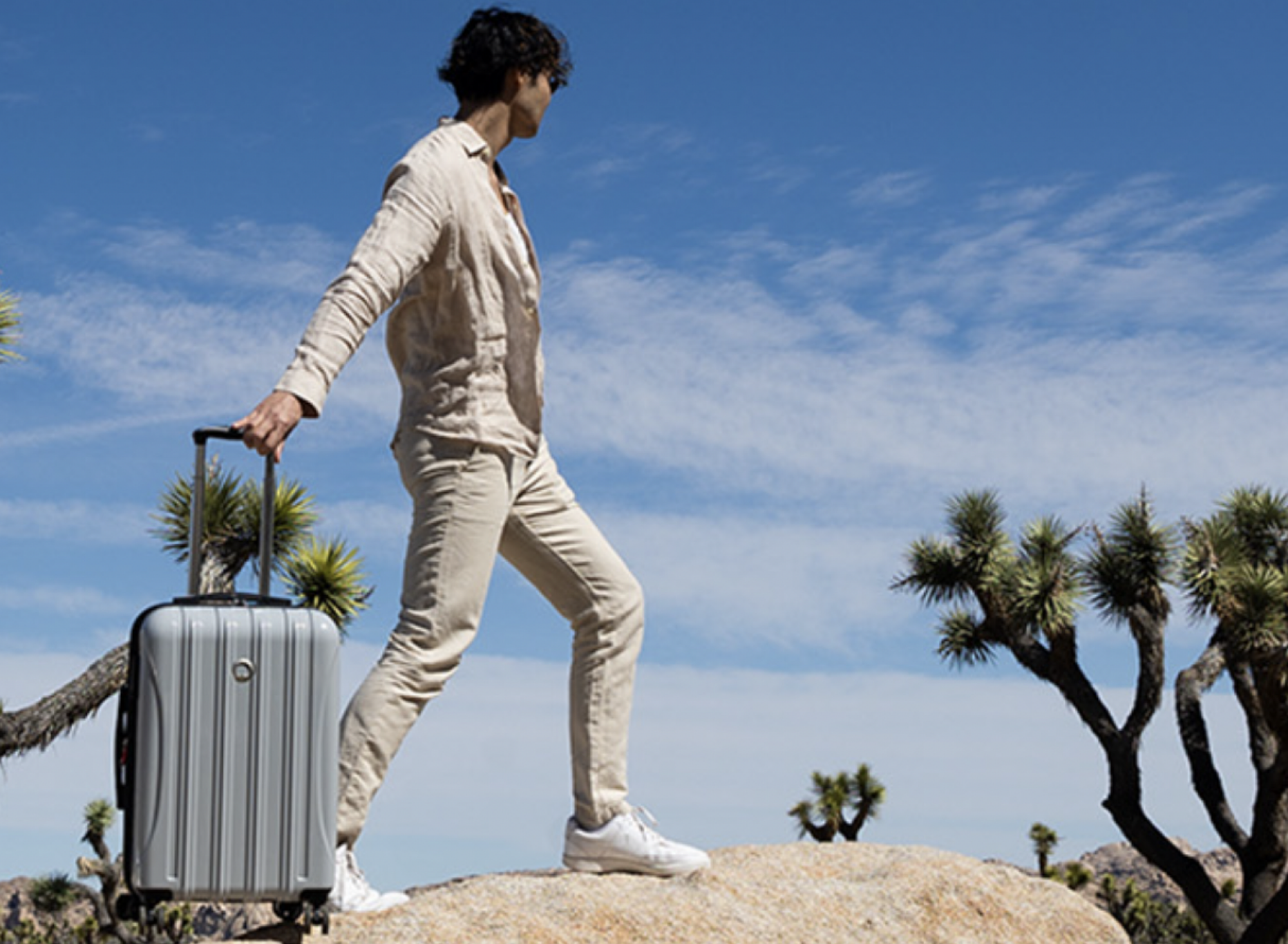 man standing on rock with suitcase