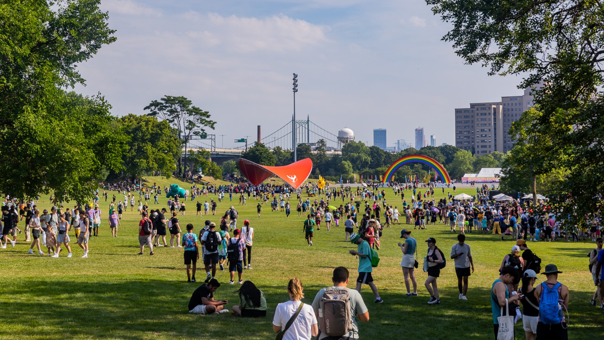 An open field in the sun, dotted with people.