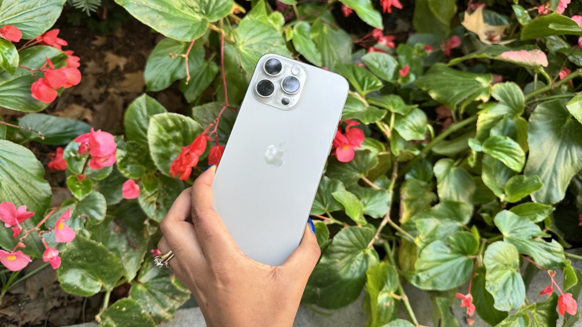 iPhone 16 Pro Max in front of a floral and verdant background