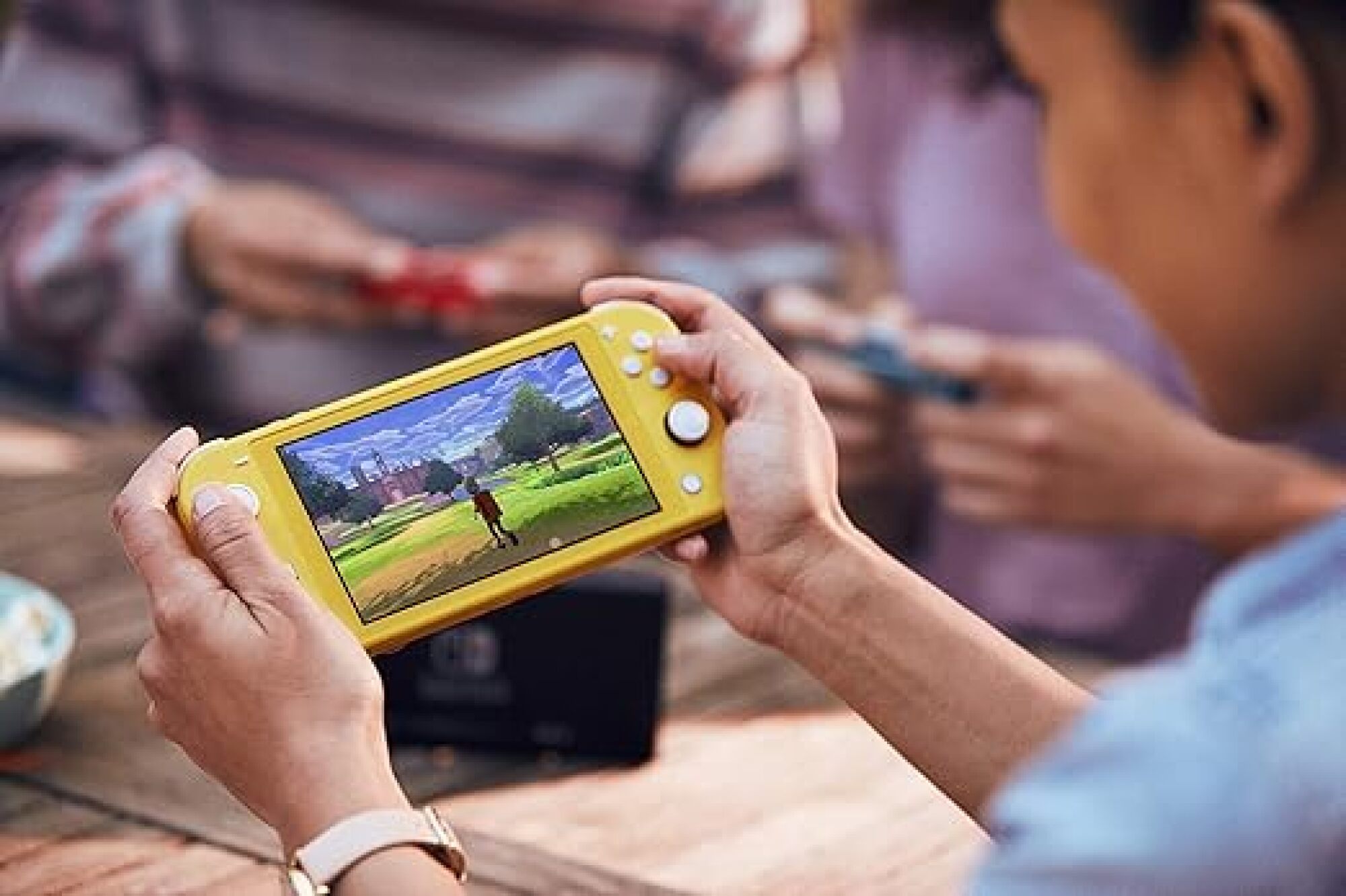 person playing switch lite in yellow