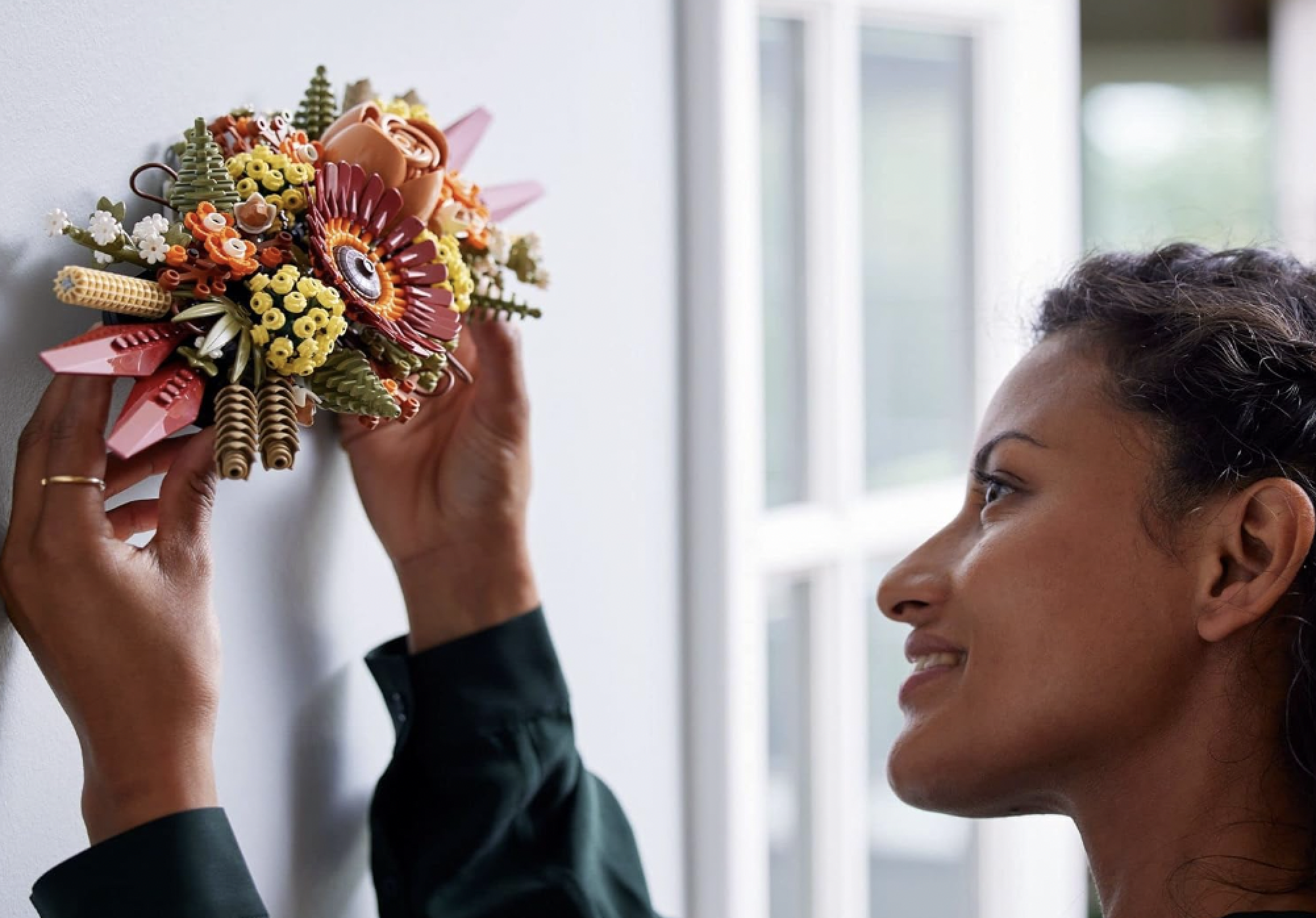 woman holding lego set against wall