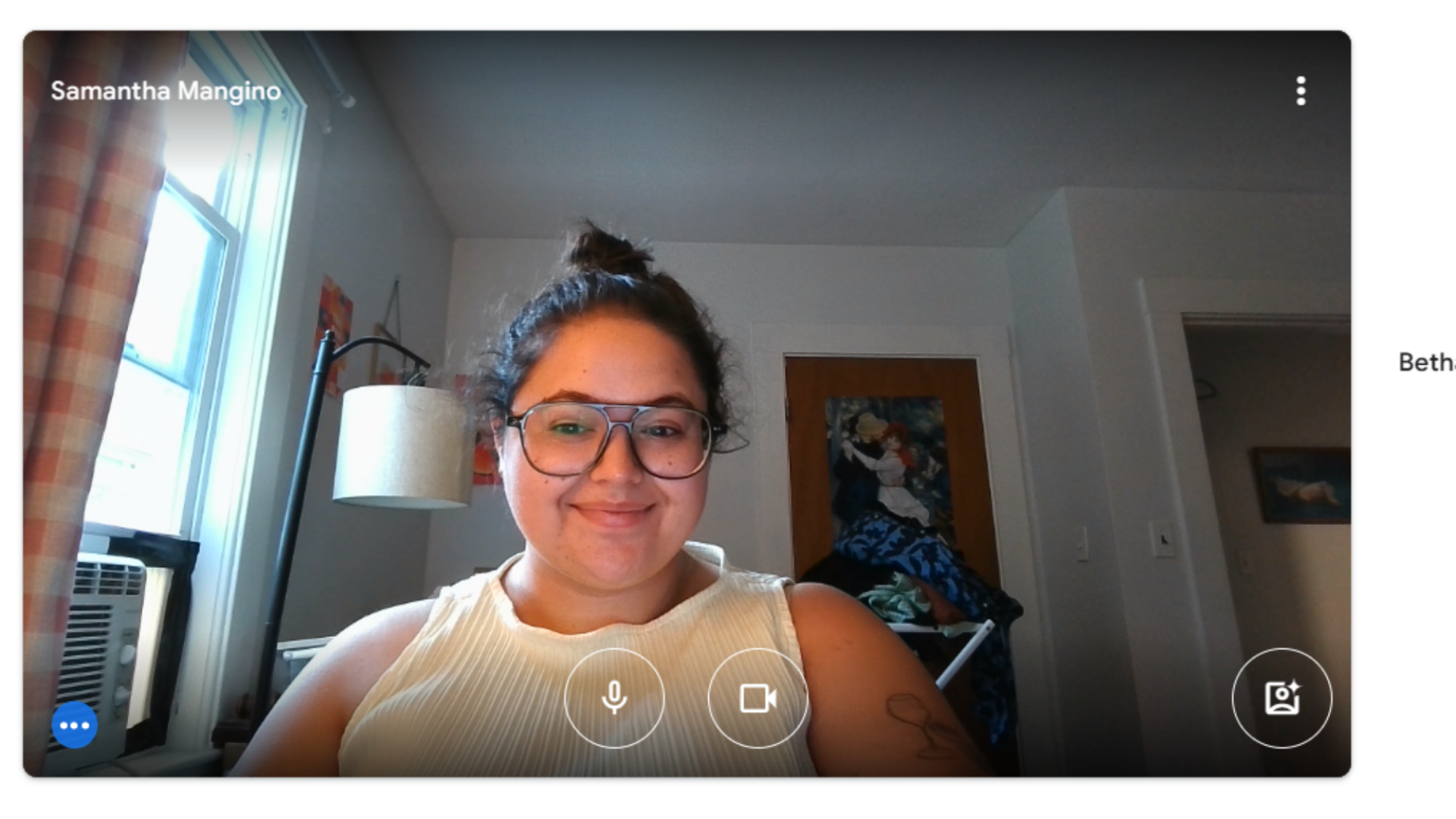 A woman sitting at a desk, looking into a webcam.