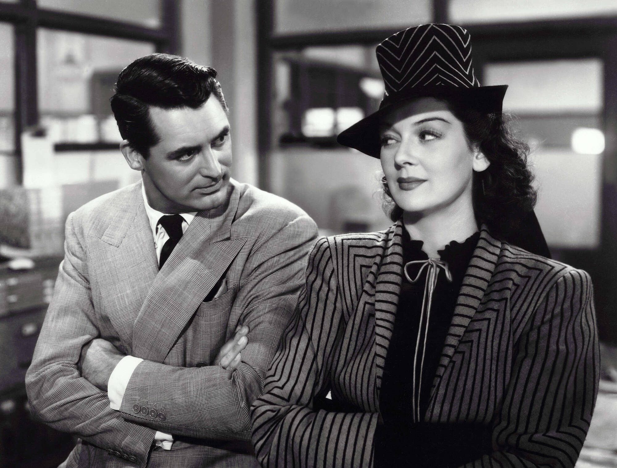 A black and white still of Cary Grant and Rosalind Russell in His Girl Friday.