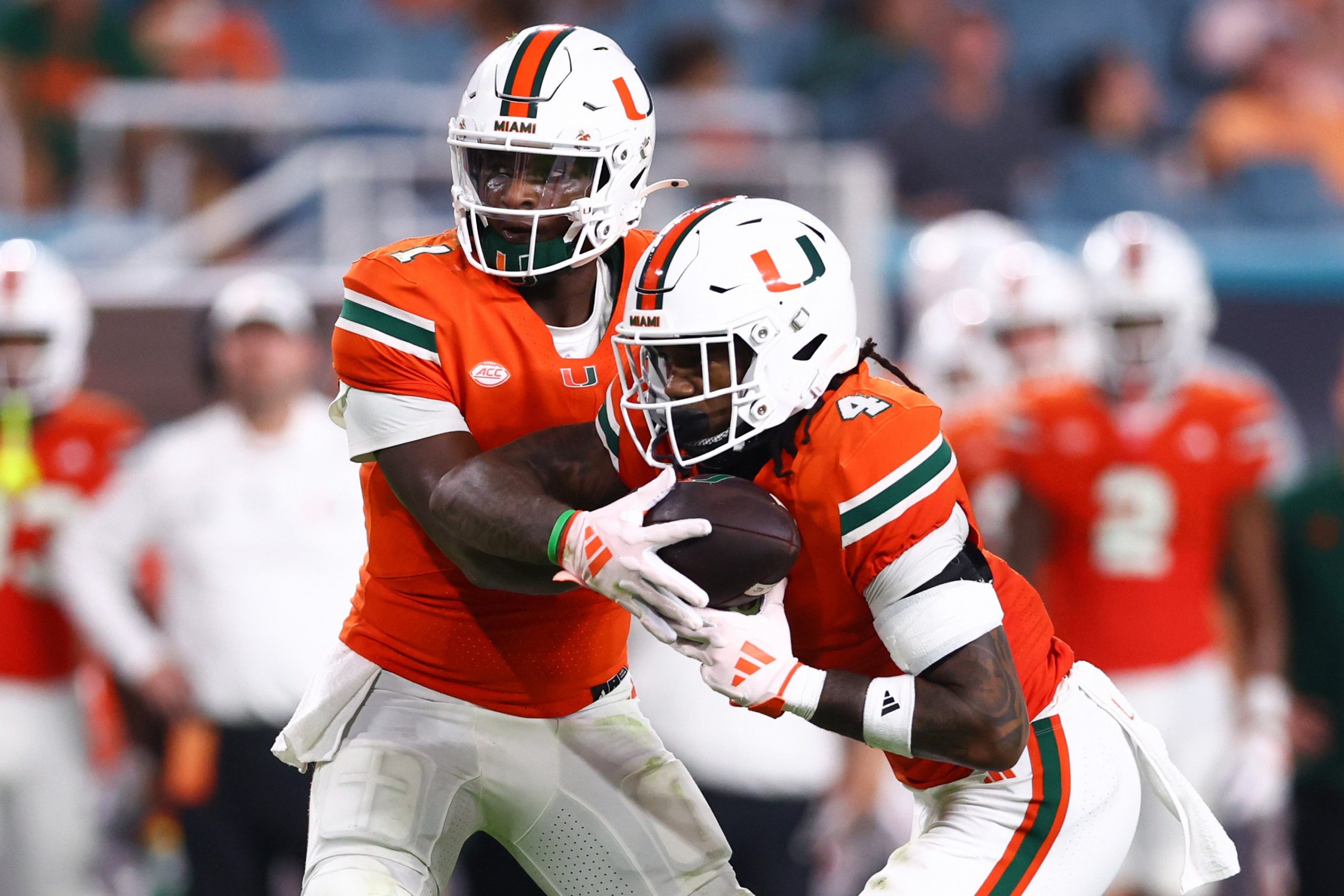 Cam Ward #1 of the Miami Hurricanes hands off the ball to teammate Mark Fletcher Jr. #4 during the first half of the game against the Virginia Tech Hokies at Hard Rock Stadium on Sept. 27, 2024, in Miami Gardens, Florida.