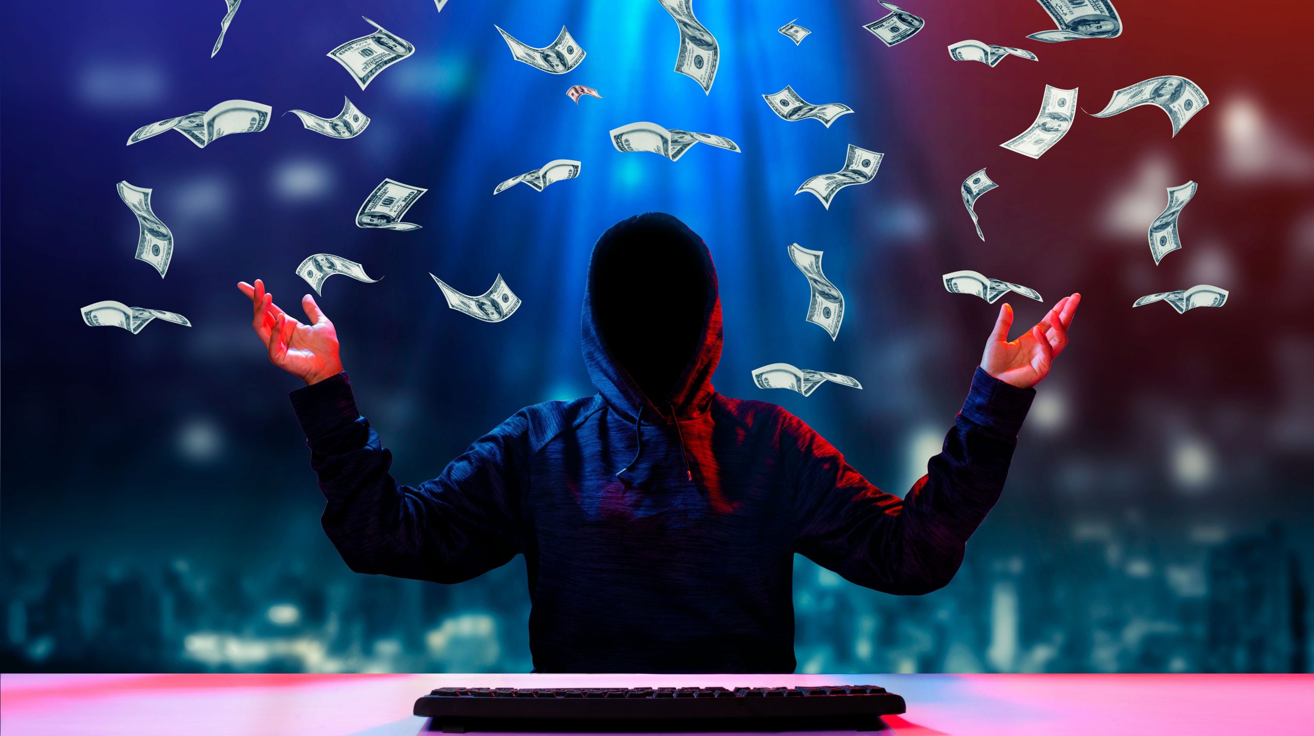 A hacker in a celebratory pose as money rains down on them