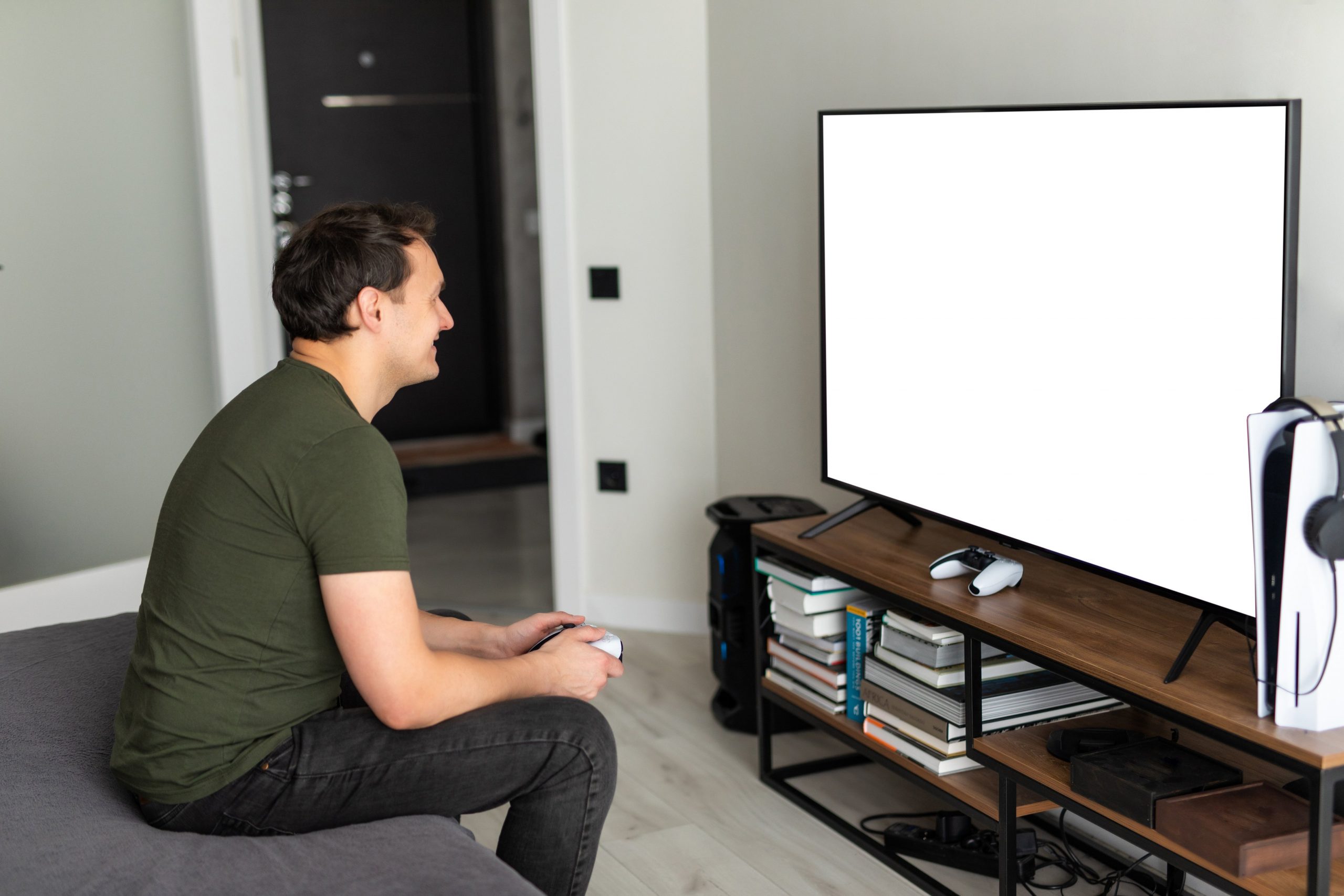 Young happy man laughing and playing video games on weekend