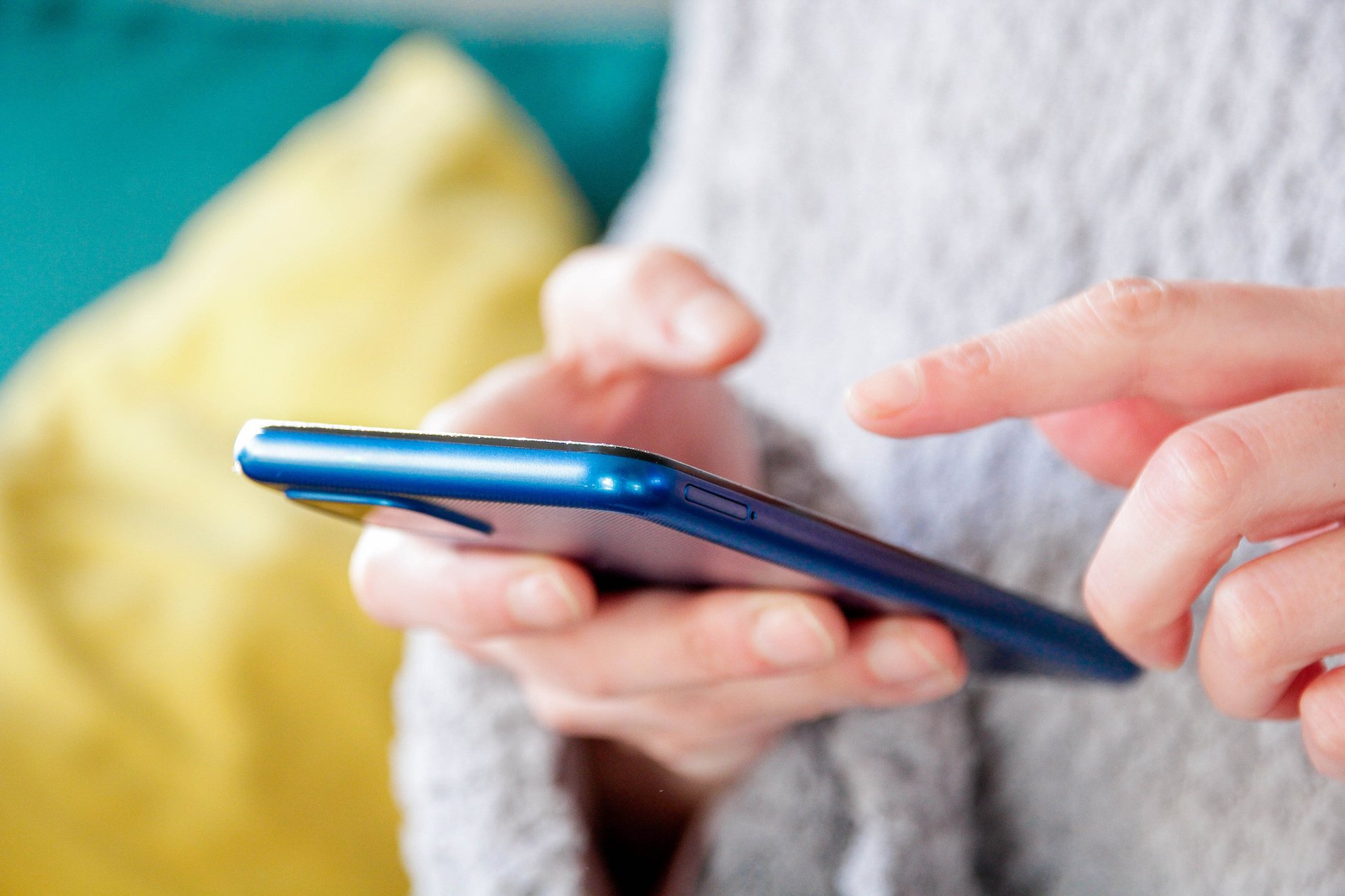 A woman holds a smartphone in her hands. 