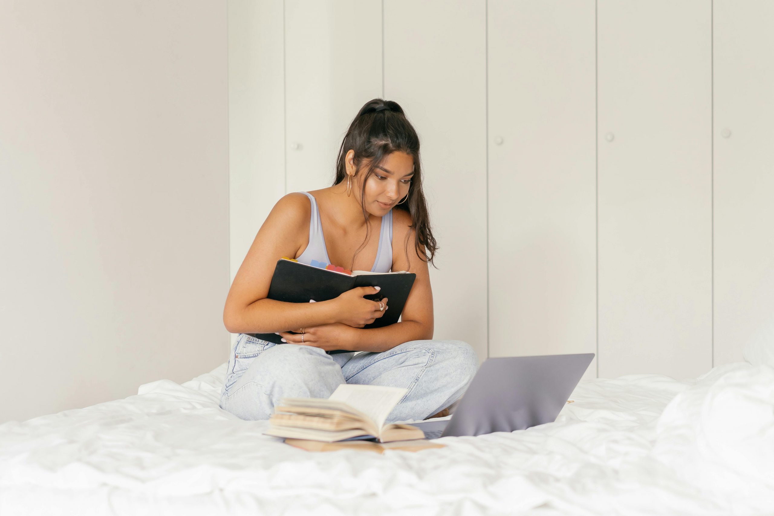 Girl holding laptop on bed