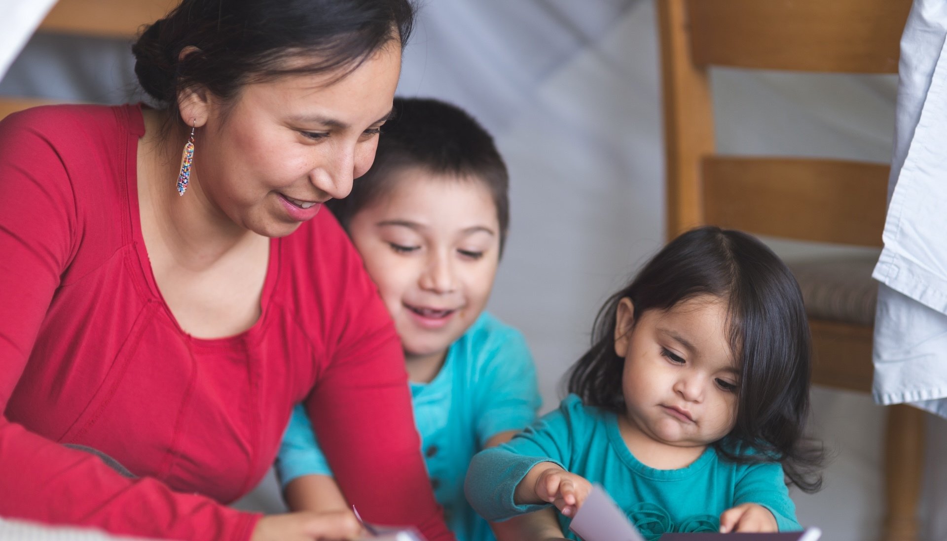 A Native American mom reads to her children.