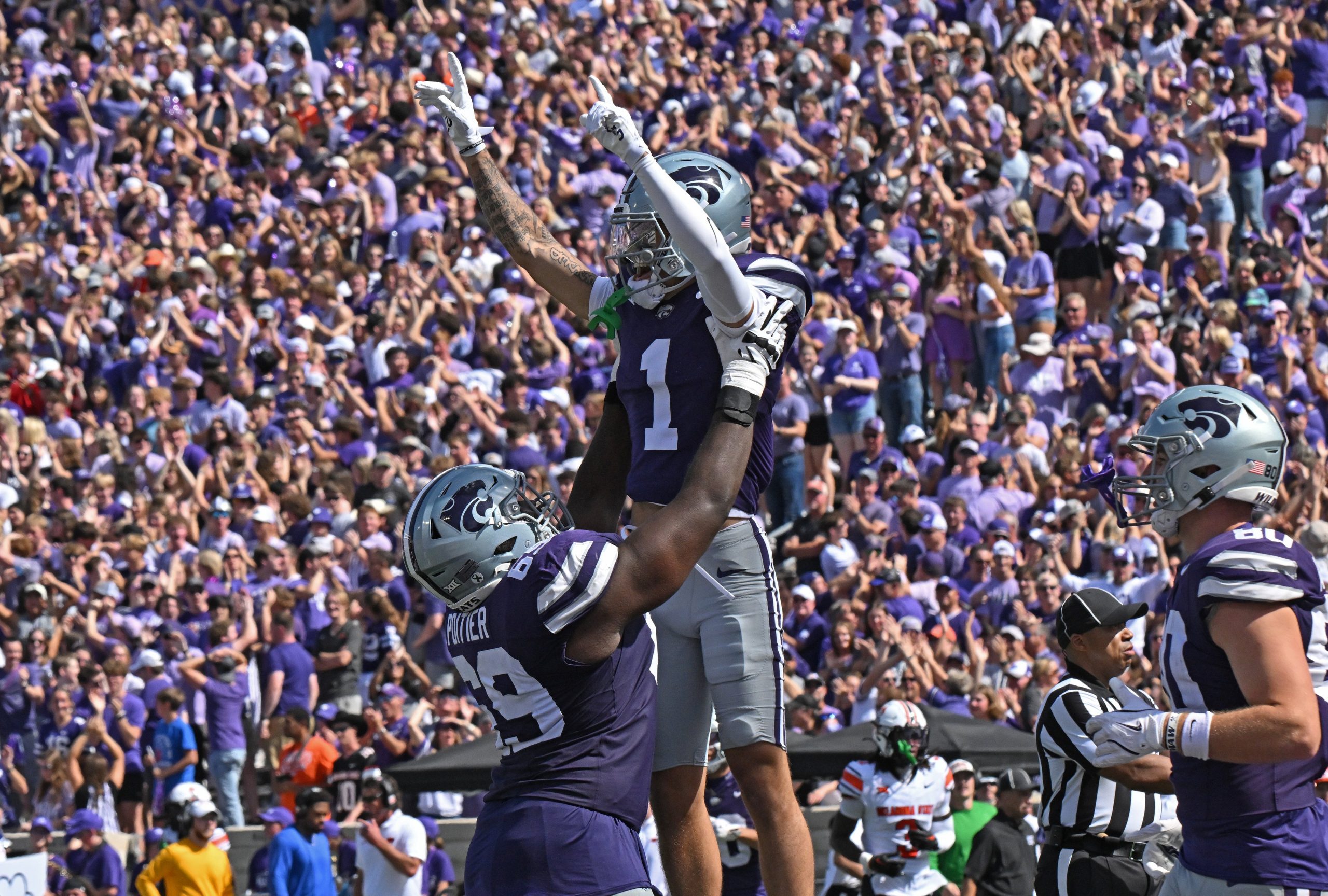 Wide receiver Jayce Brown #1 of the Kansas State Wildcats celebrates with offensive lineman Taylor Poitier #69