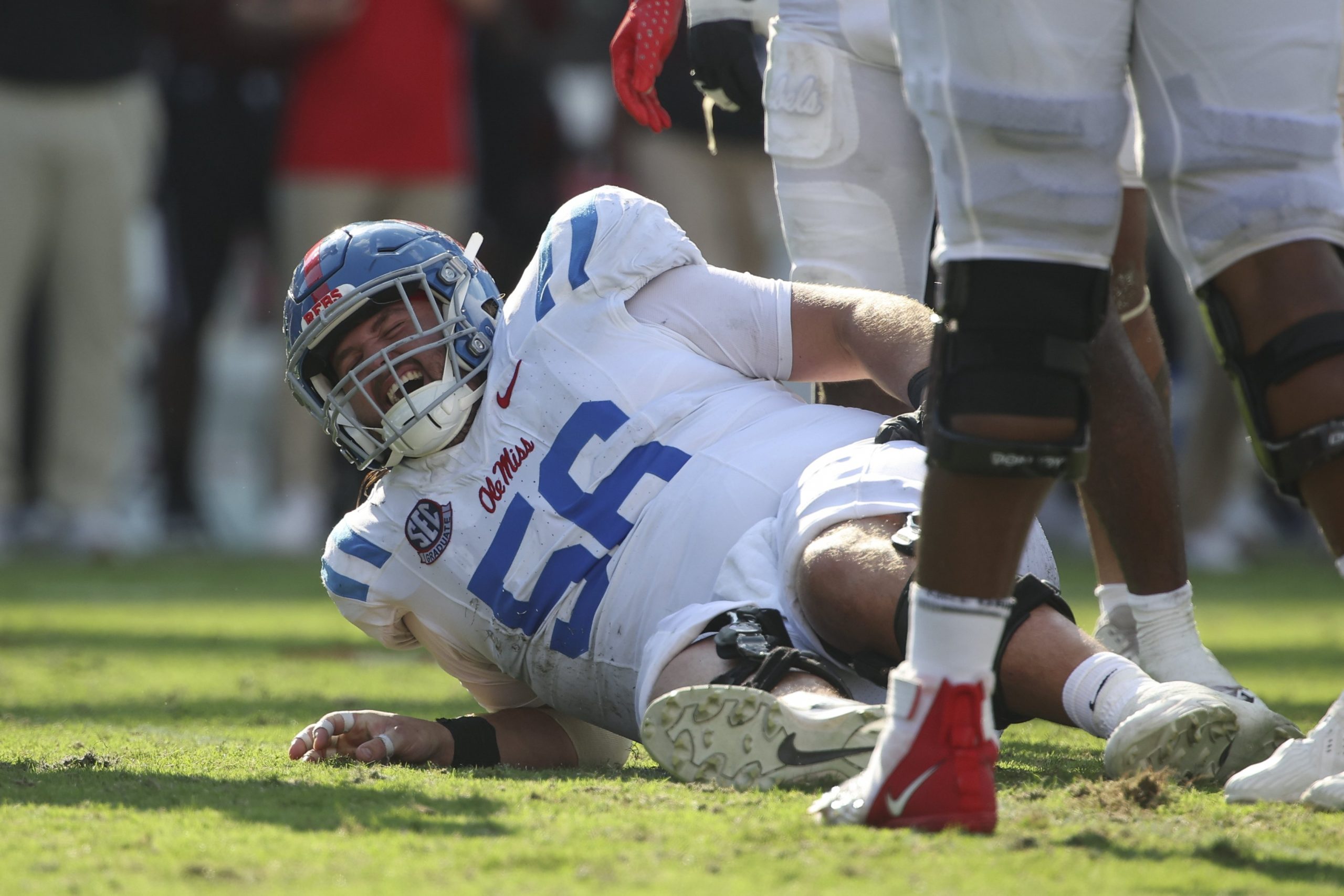 Mississippi Rebels offensive lineman Reece McIntyre (56) holds his leg in pain 