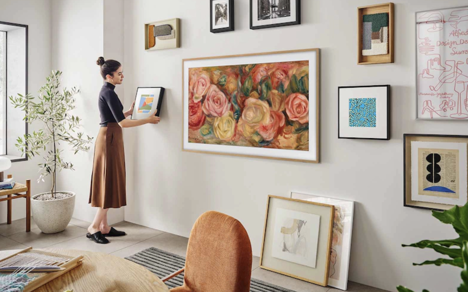 woman hanging art on wall