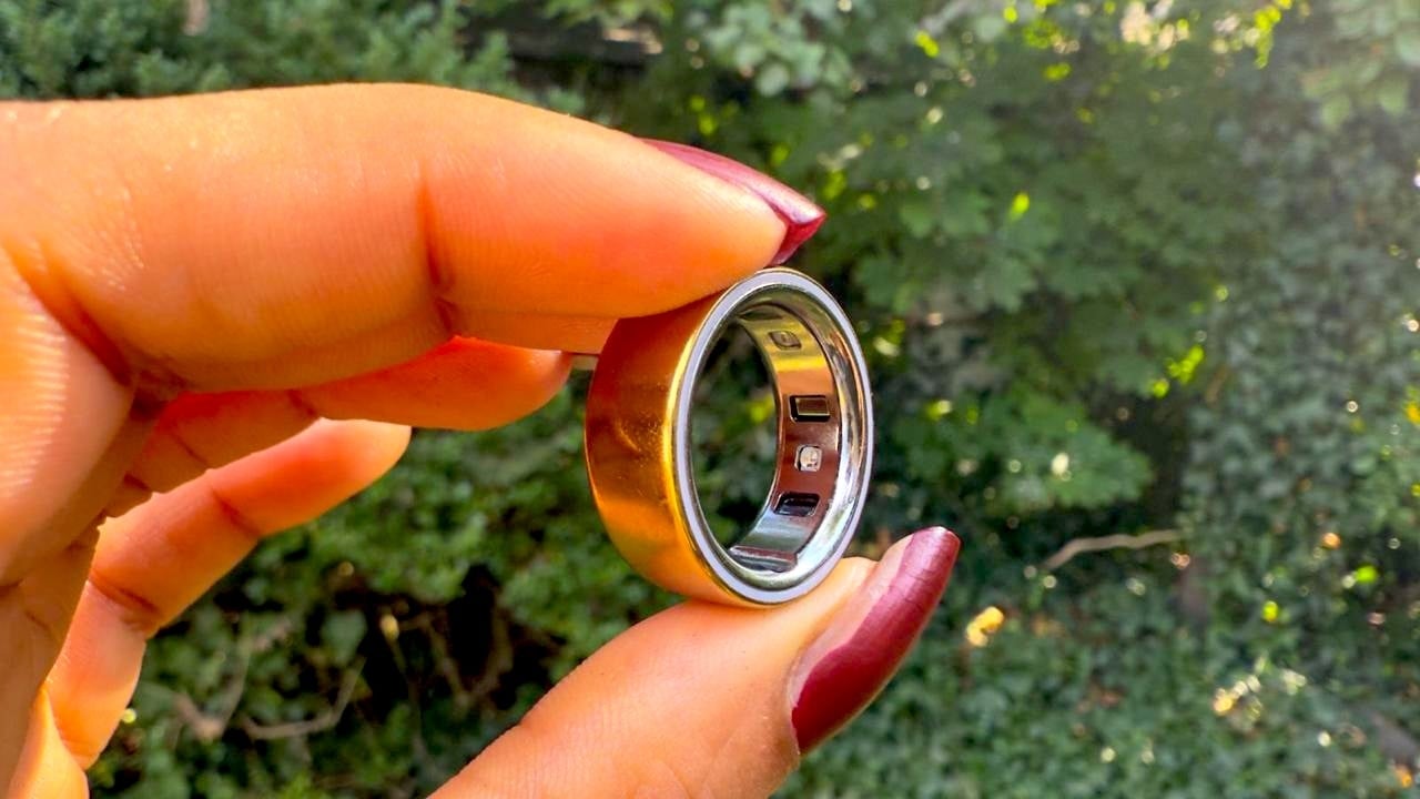 Woman holding Oura Ring 4 in between her thumb and pointer finger