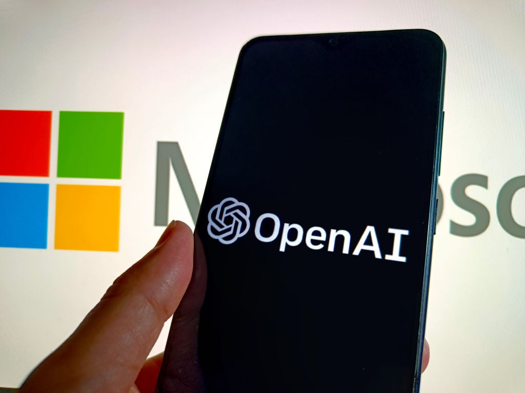 OpenAI logo on a smartphone against the backdrop of the Microsoft log