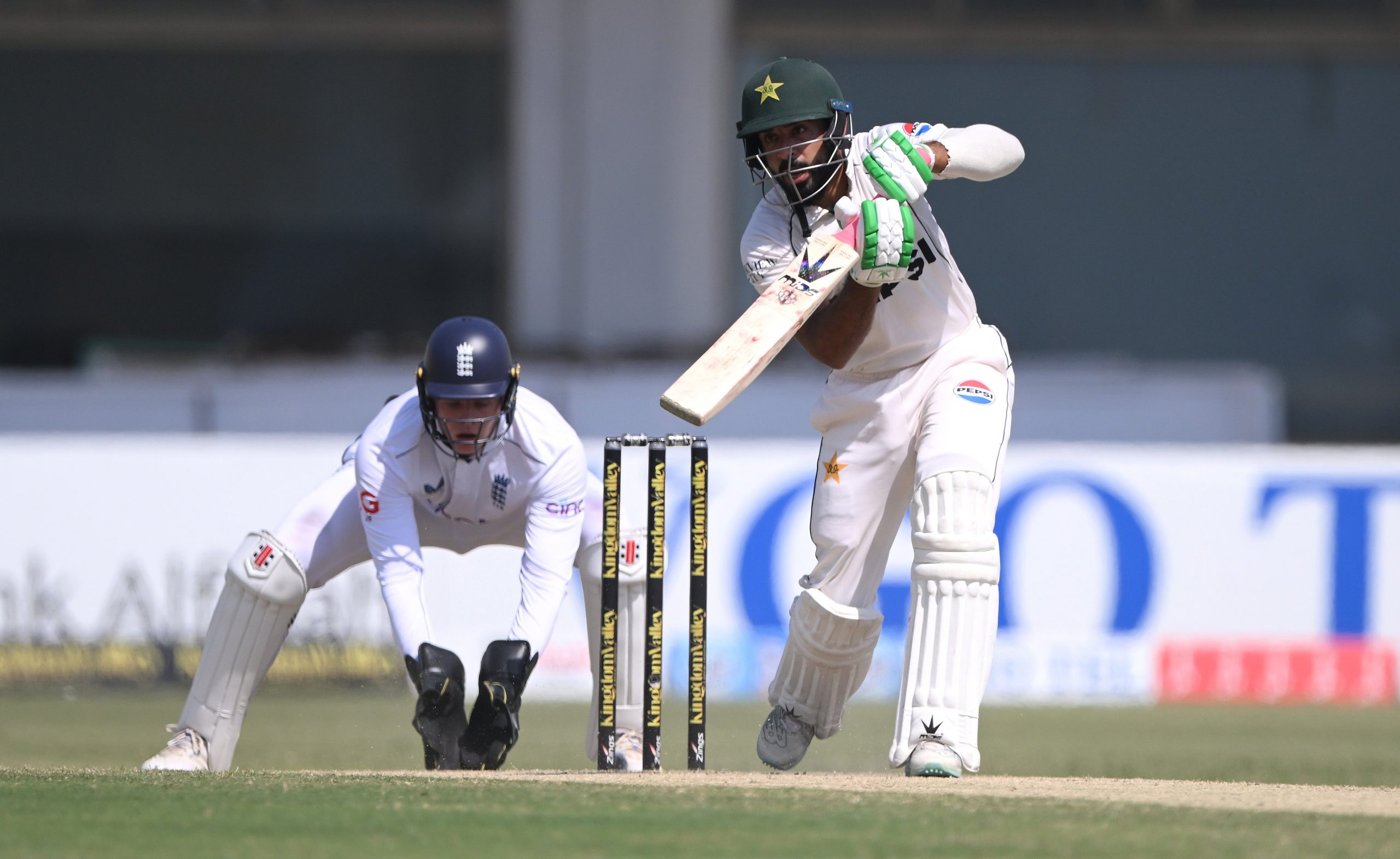 Pakistan batsman Aamer Jamal hits out watched by Jamie Smith