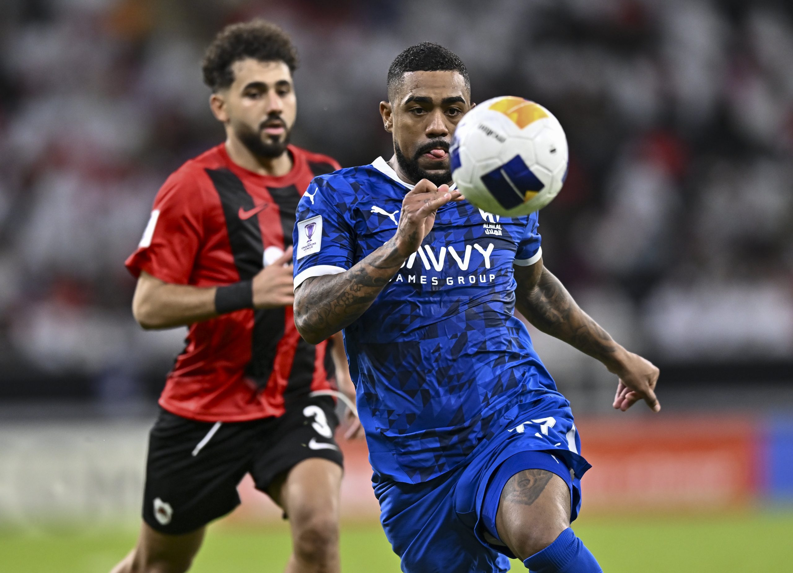 Hazem Ahmed Shehata of Al-Rayyan SC battles for the ball with Malcom Oliveira