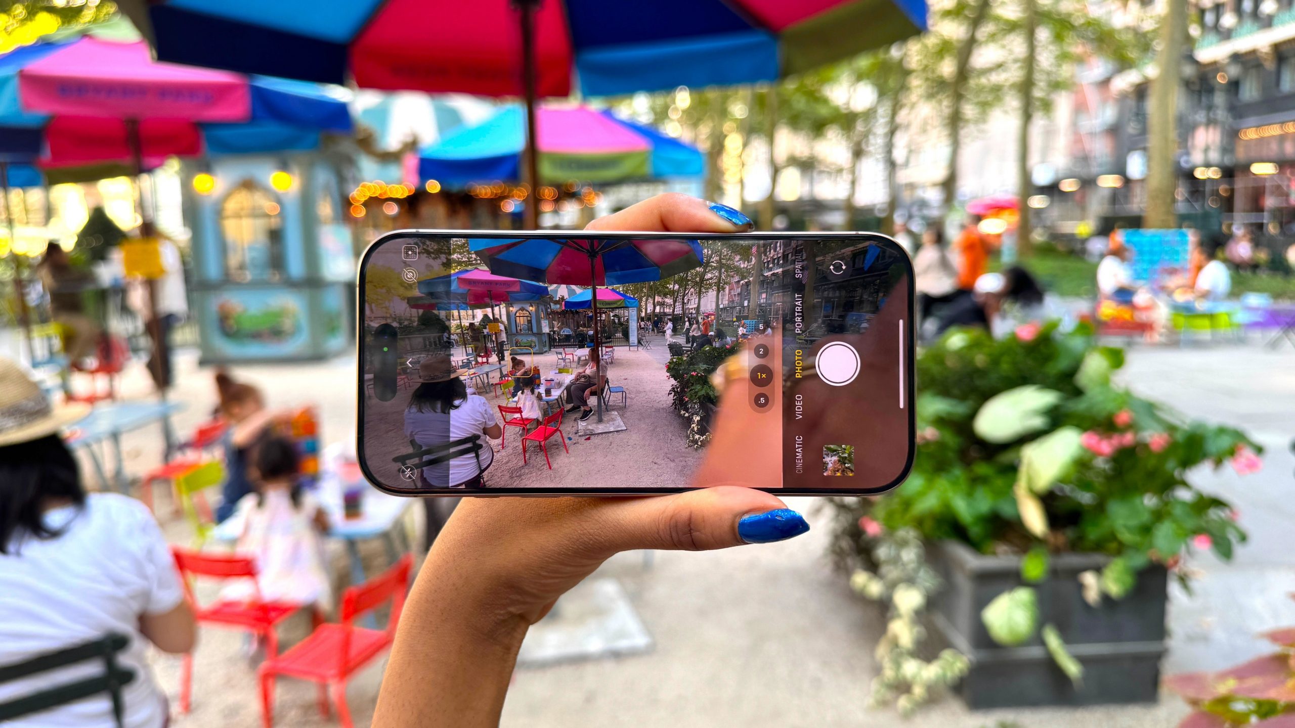 Woman holding iPhone 16 Pro Max inside Bryant Park