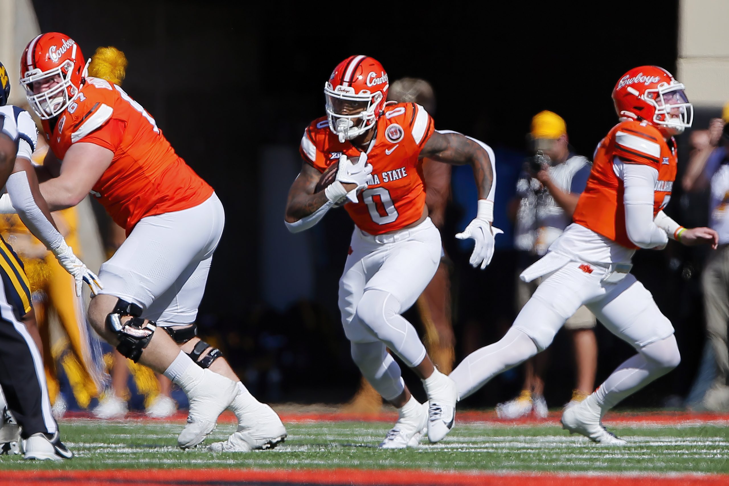 Oklahoma State player carries the ball down the field.