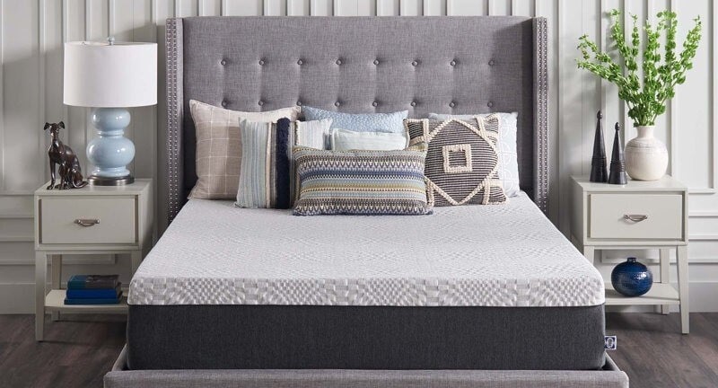 a sealy bed in a bedroom with gray and blue tones