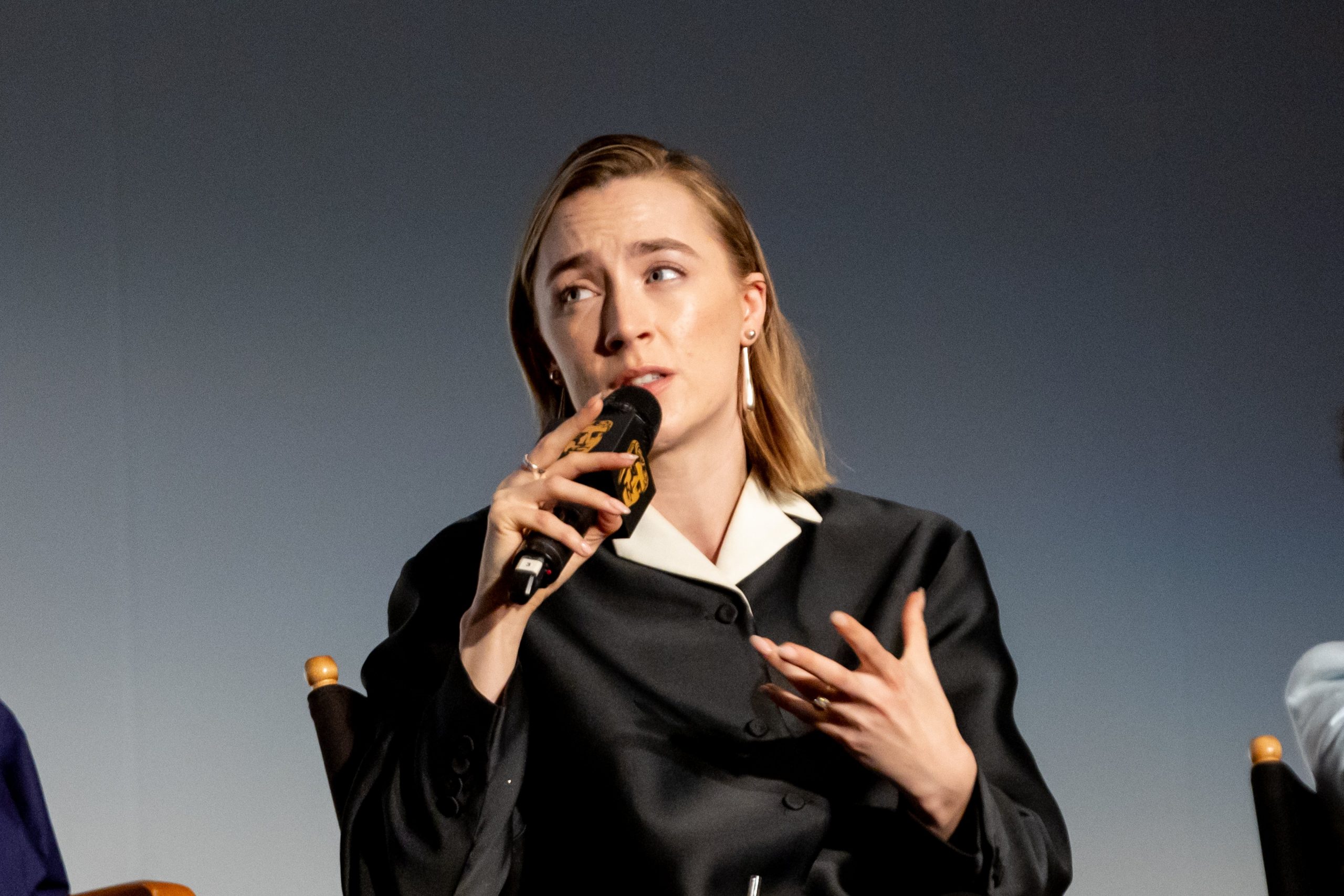 Saoirse ronan on stage, speaking into a microphone