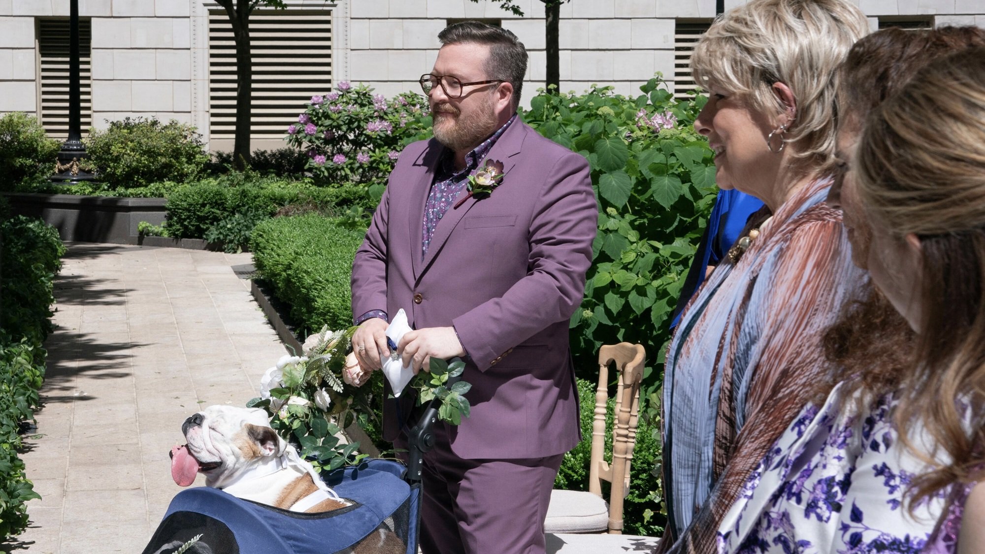 Michael Cyril Creighton as Howard in "Only Murders in the Building," pushing a bulldog in a stroller down the aisle at a wedding.