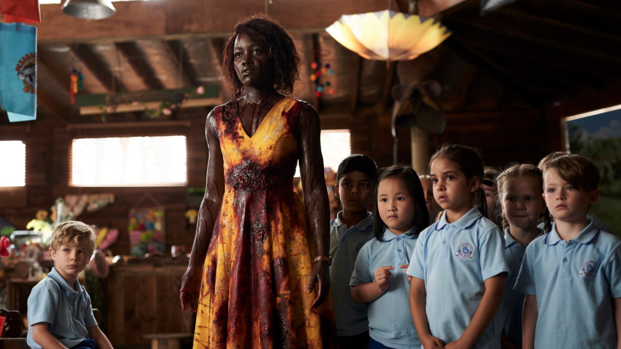 Lupita Nyong'o stands with a class of kindergarteners, covered in blood, in the film "Little Monsters."