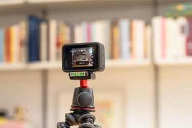 go pro hero 13 black on tripod in front of bookshelf